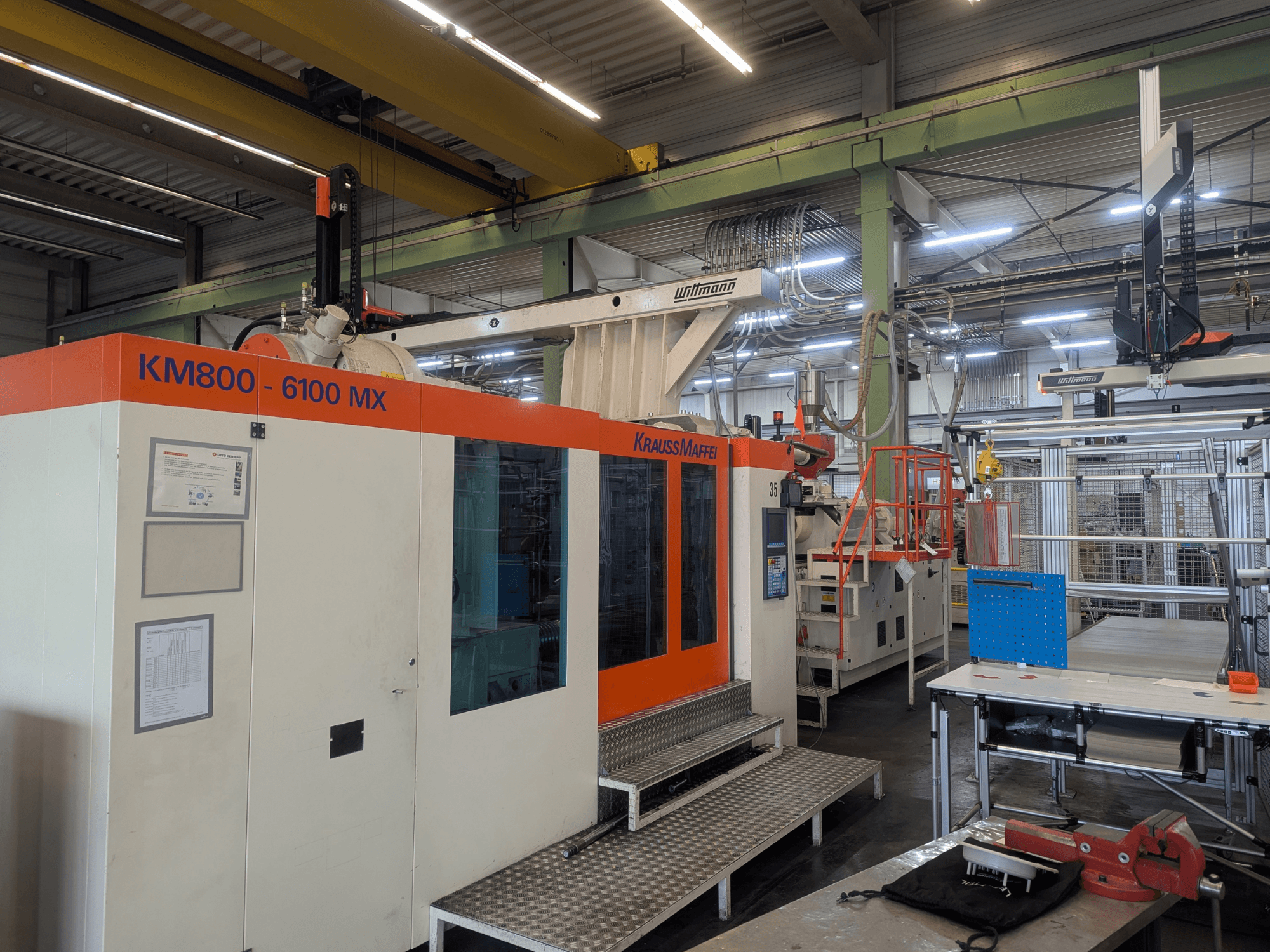 Krauss Maffei KM 800-6100MX hidrolik enjeksiyon kalıplama makinesi, önden görünüm, kontrol paneli ve endüstriyel kurulum.