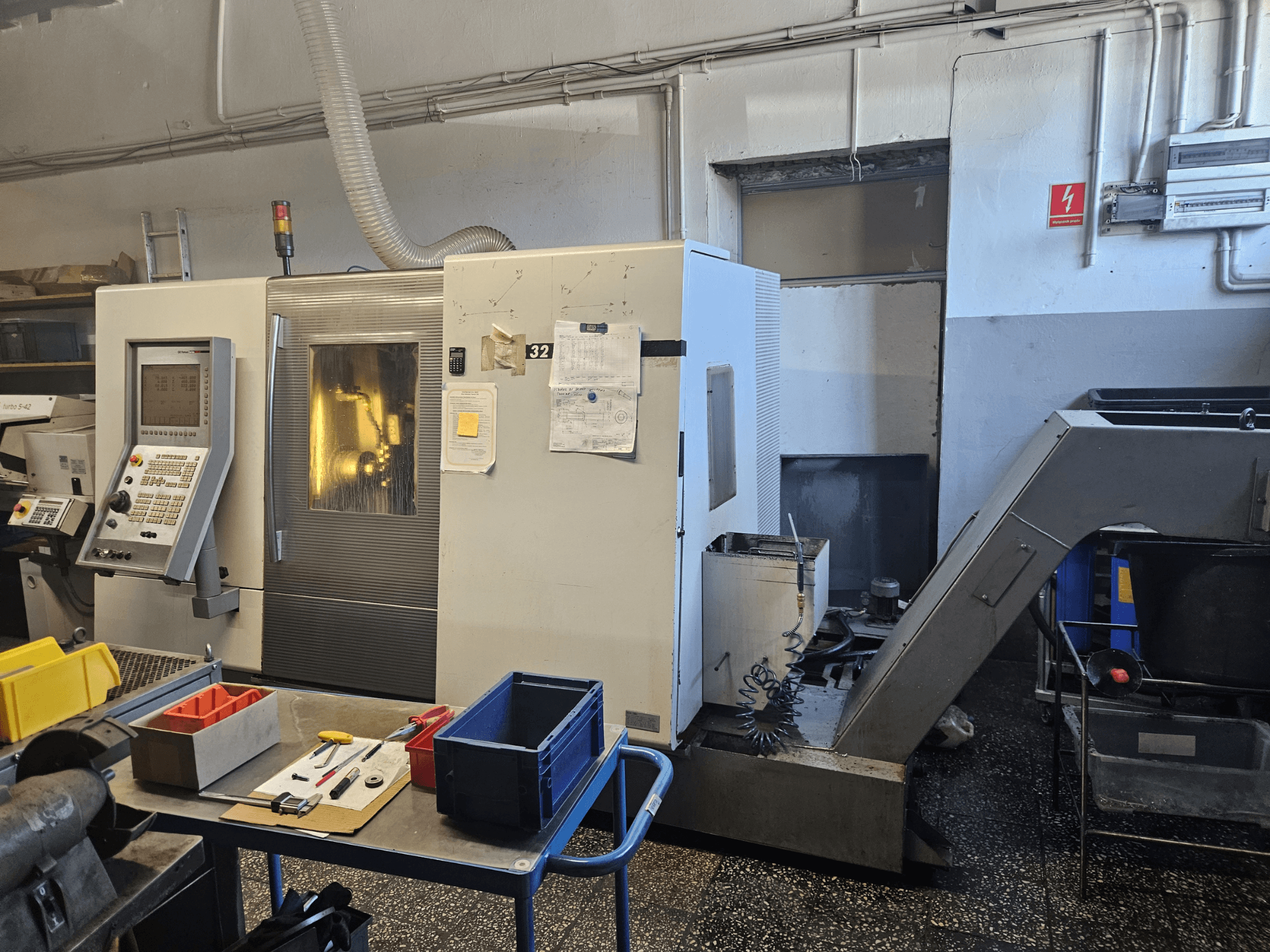 Çok milli torna makinesi DMG GILDEMEISTER Sprint 32 lineer, atölyede önden görünüm, kontrol paneli ve takımlar görünür.