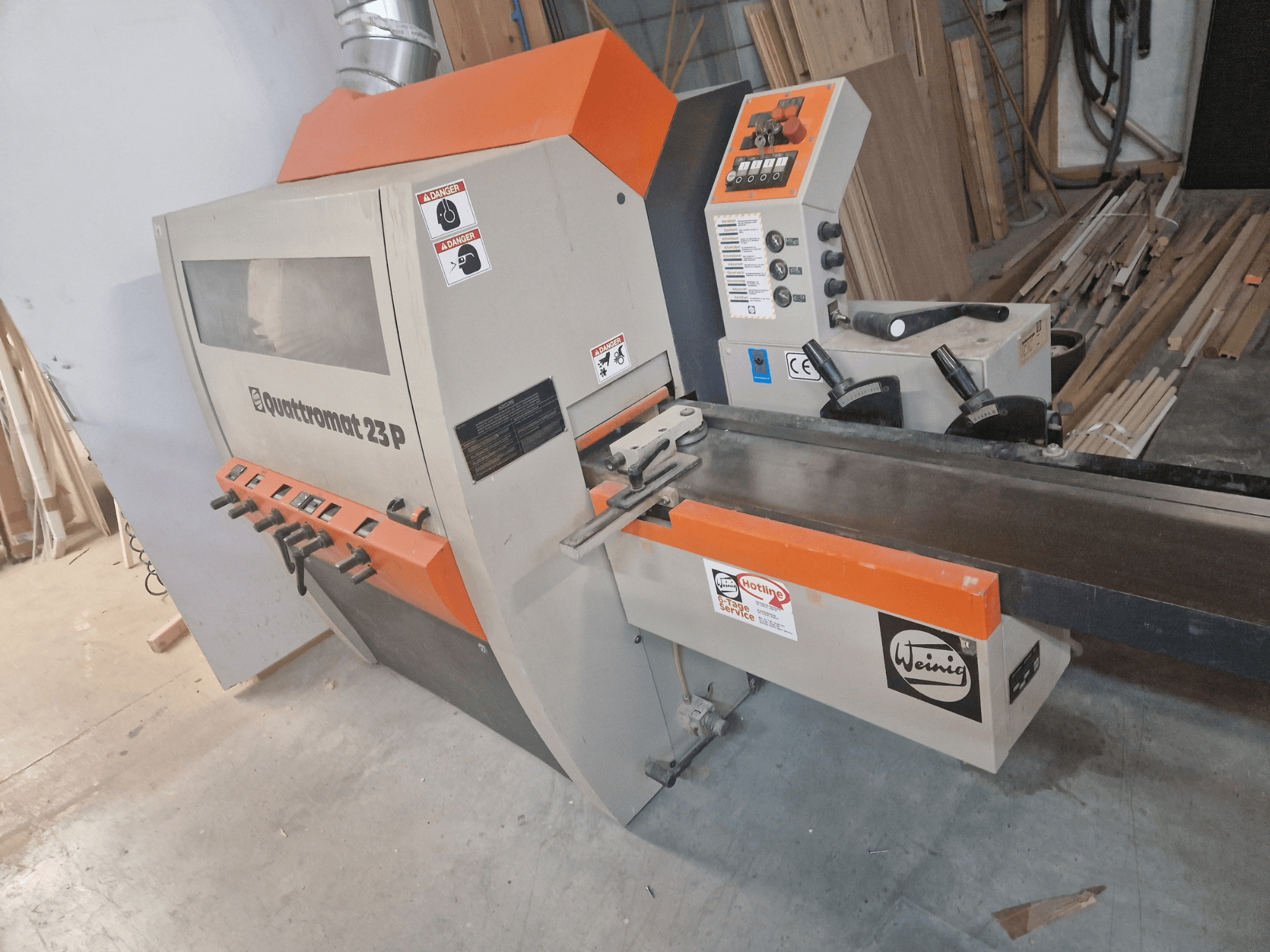 Weinig Quadtr الضوم 23 P modeli, kontrol paneli ve güvenlik uyarıları ile bir ahşap freze makinesinin önden görünümü.