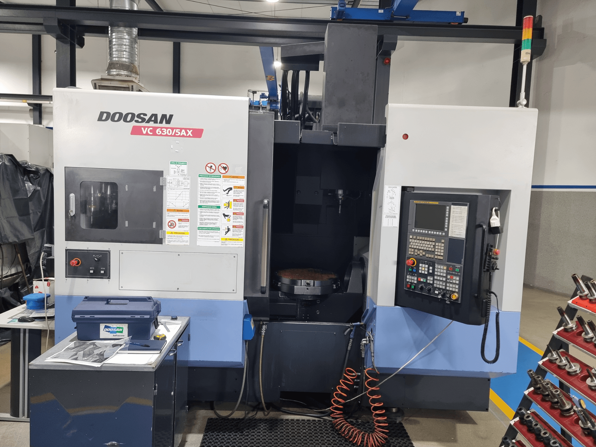 DOOSAN VC 630/5AX çok amaçlı işleme merkezi; kontrol paneli, kesme alanı ve güvenlik özelliklerini gösteren önden görünüm.