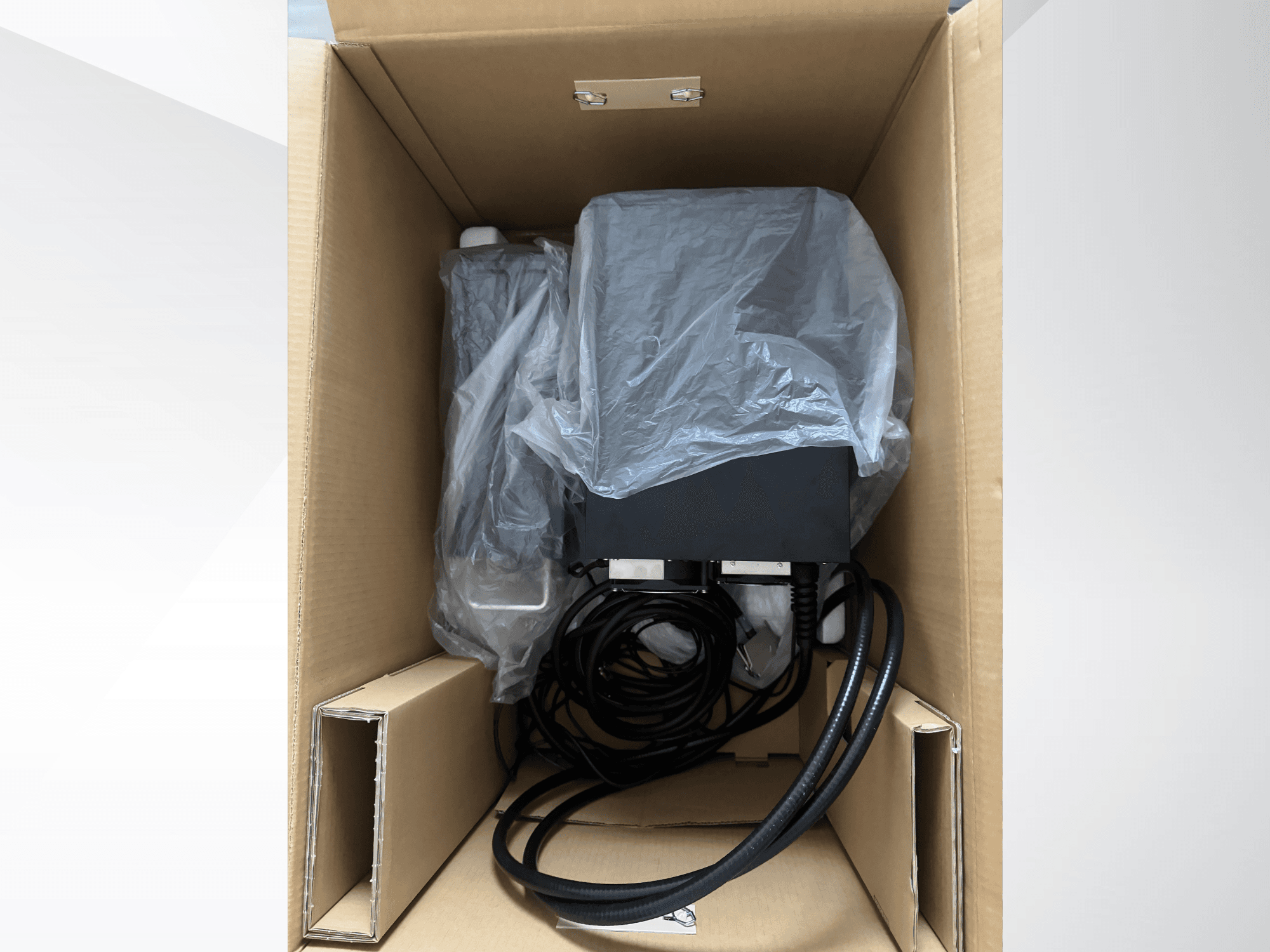 KEYENCE MD-X2500A Lazer İşaretleme Makinesi, karton kutu içinde, kısmen plastikle kaplı, kabloları ve bileşenleri görülebilen halde.