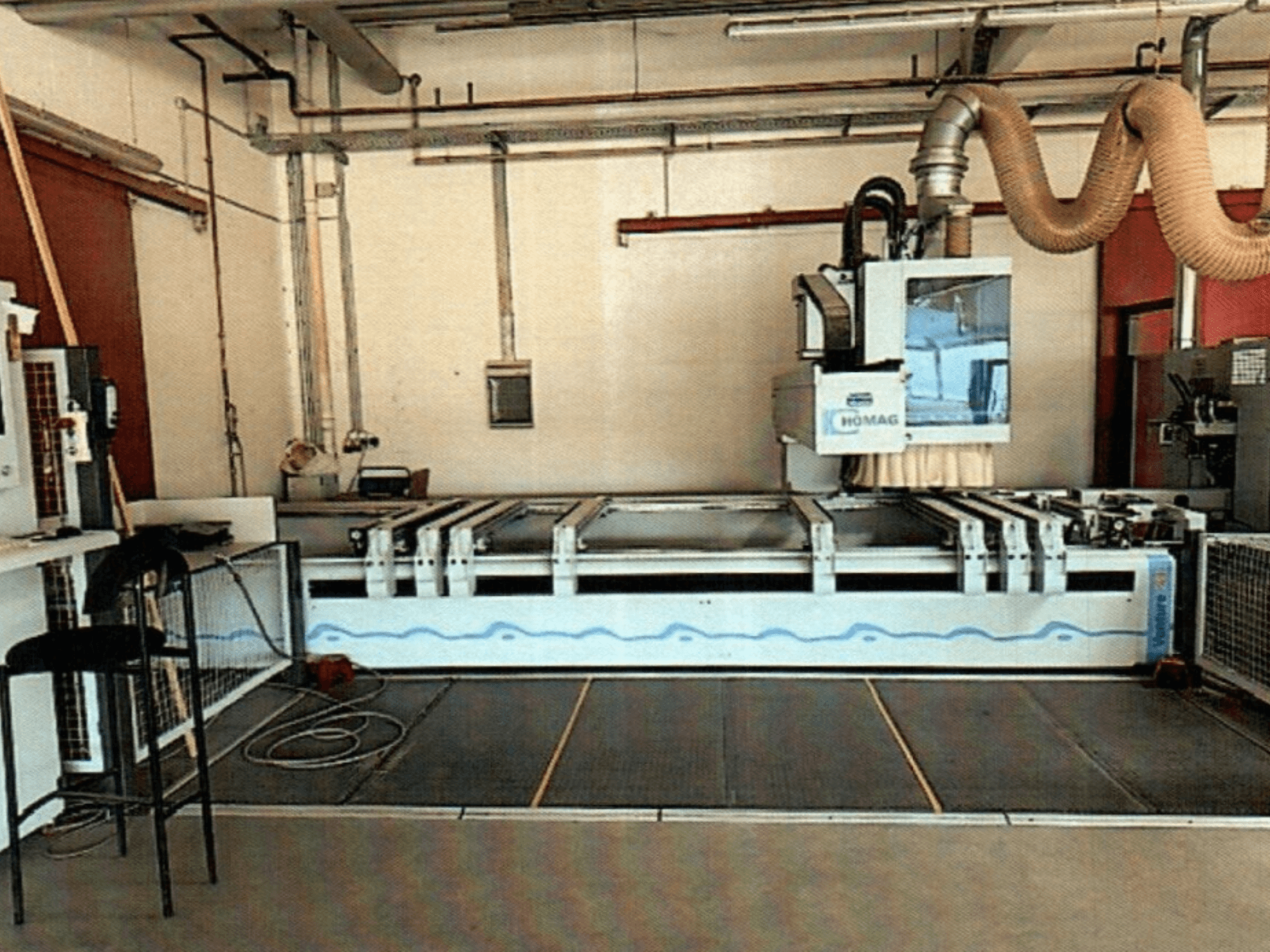 HOMAG BAZ 211/40K CNC ahşap işleme merkezi bir atölyede, makinenin kontrol panelini ve kesim alanını sergiliyor.