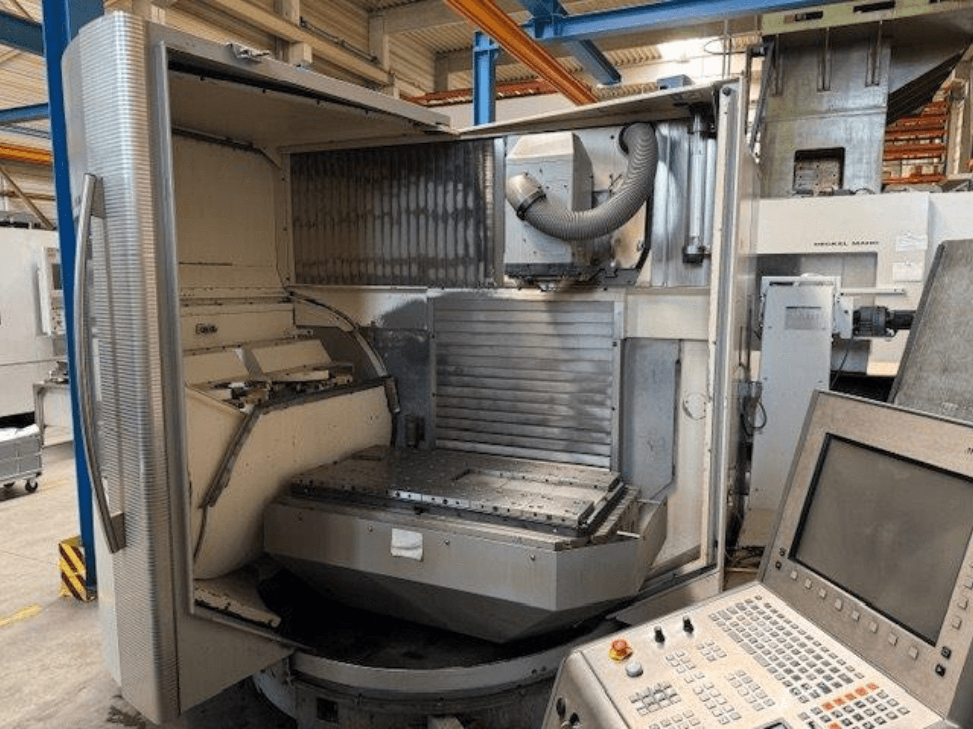 DMG MORI DMU 80T dikey işleme merkezi, açık muhafazayı ve kontrol panelini gösteren önden görünüm.