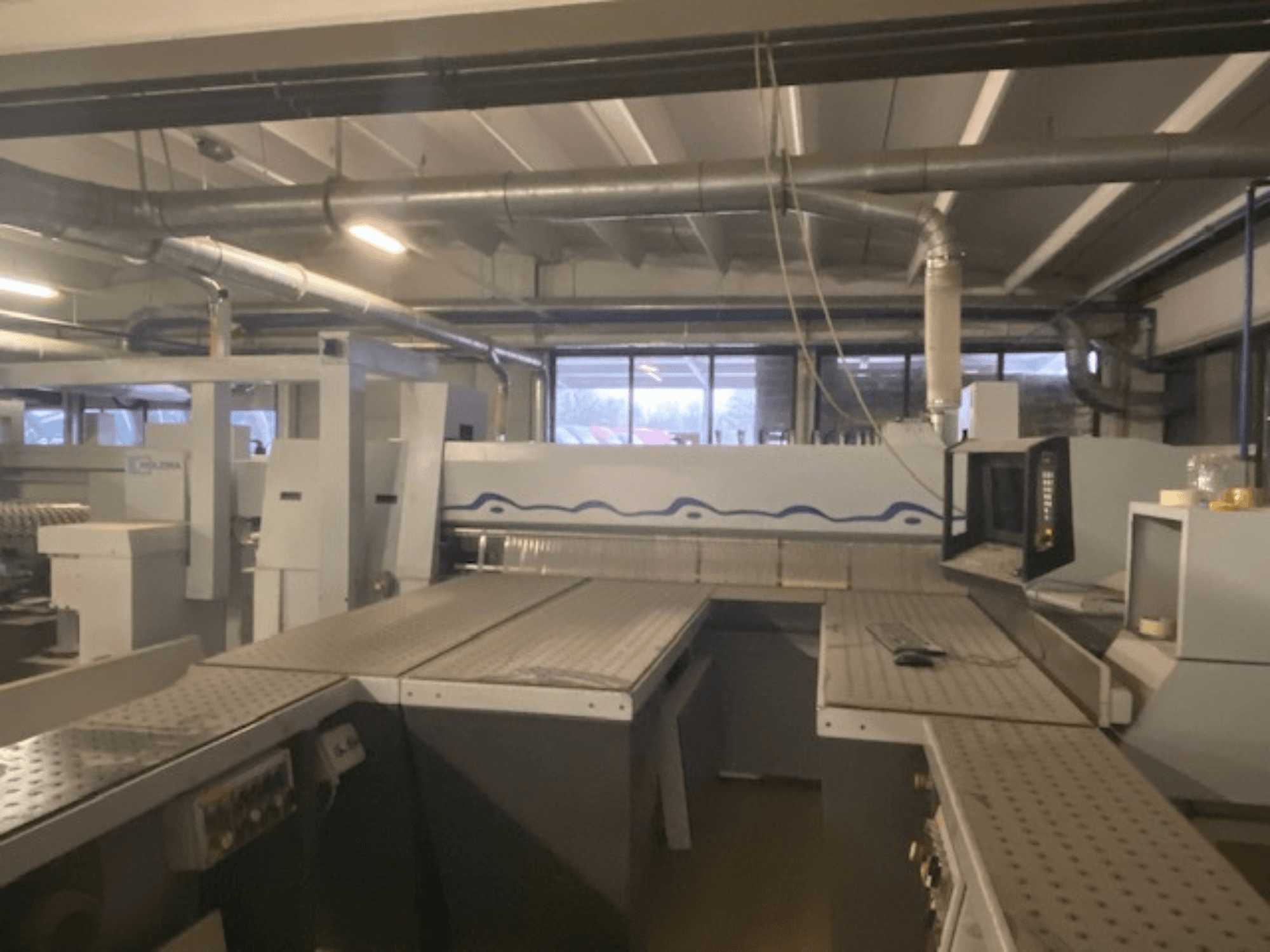 Yüksek bir ön açıdan bakıldığında, kontrol panelli bir makine kurulumunu içeren endüstriyel çalışma alanı.