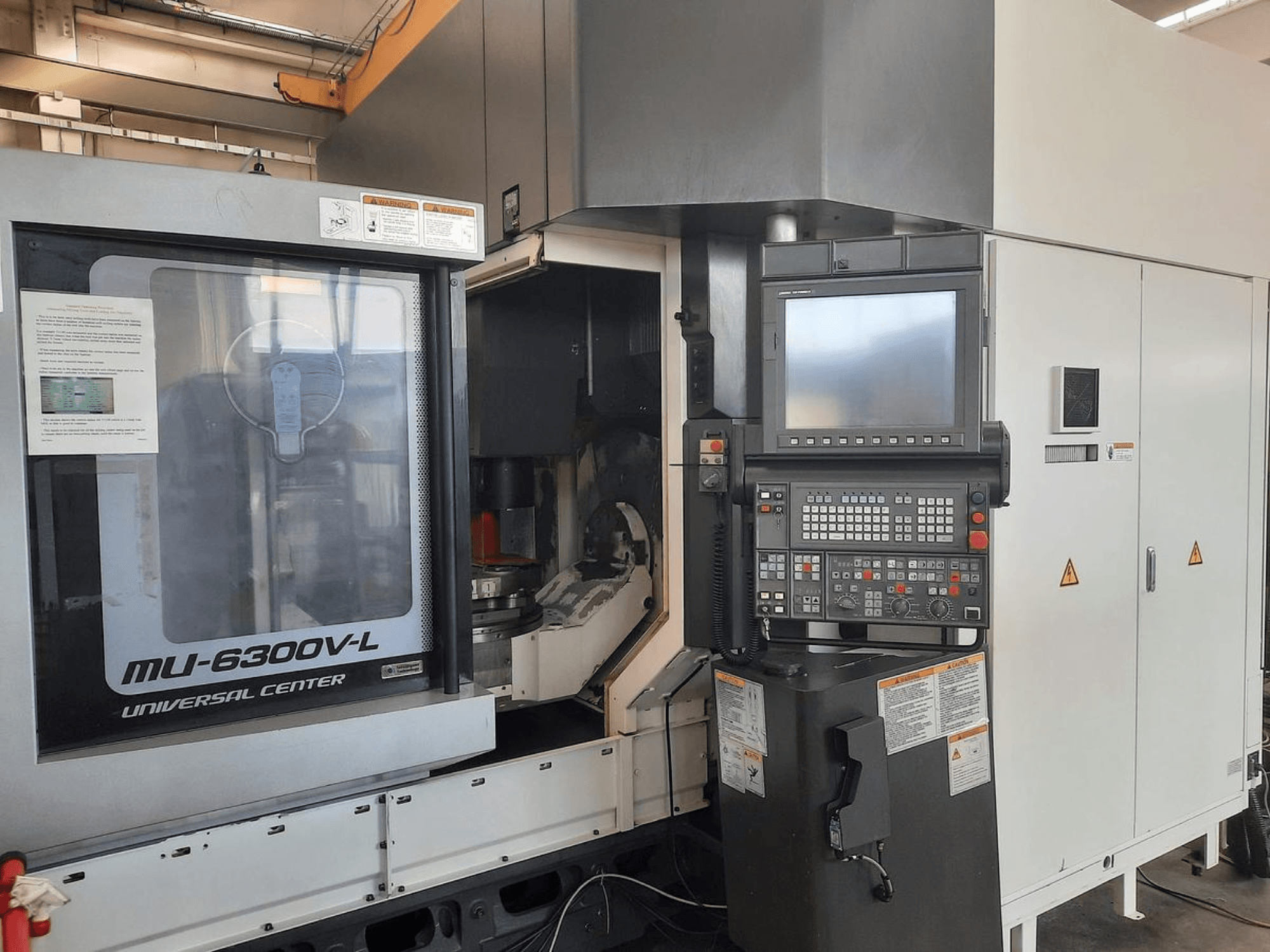 MU-6300V-L Universal Center makinesi önden gösterilmiştir, kontrol paneli, ekran ve kullanım talimatları görülebilir.