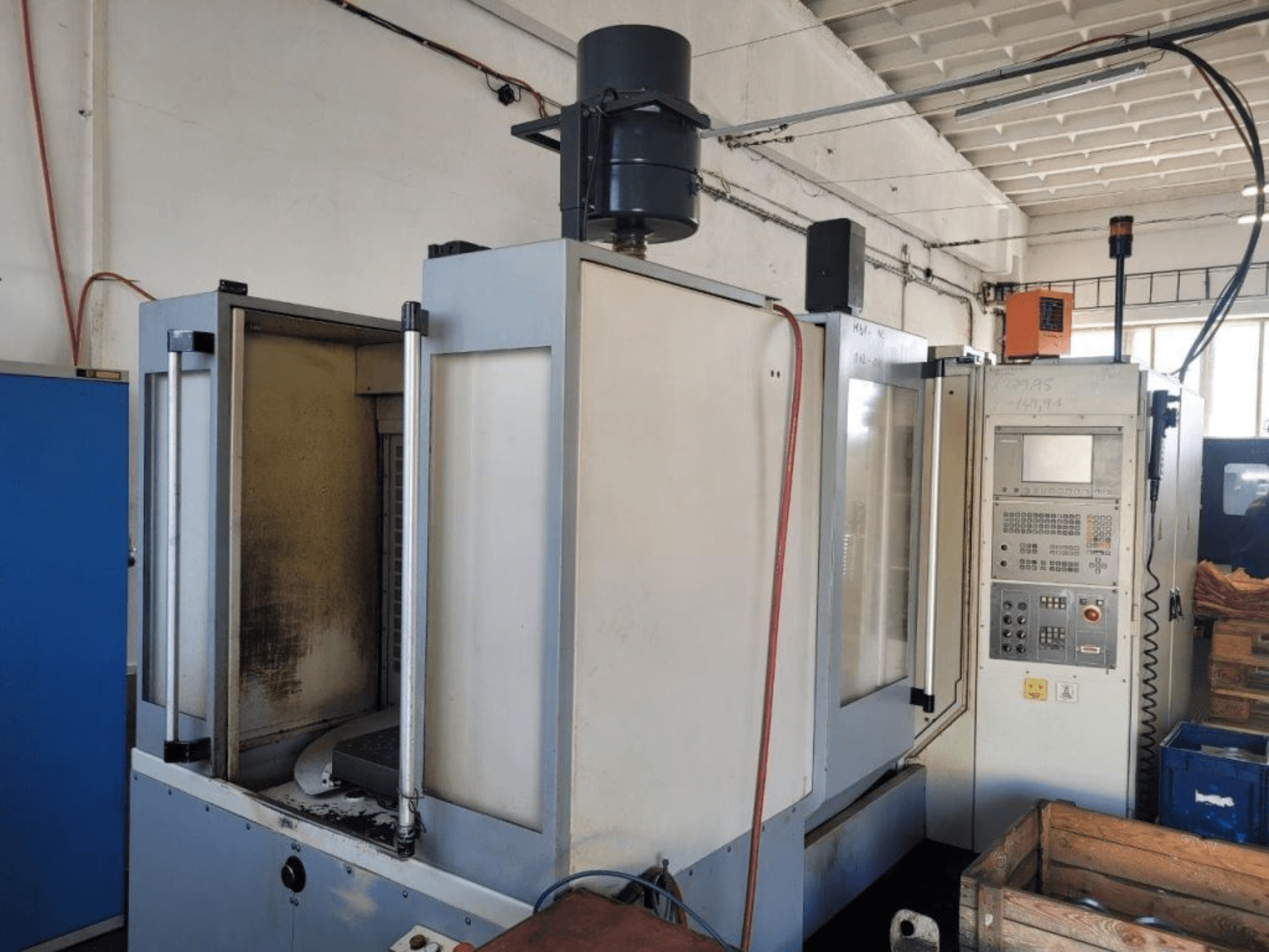 Kontrol panelli endüstriyel CNC freze makinesi, yandan görünüm, muhafazayı ve yüzeylerdeki görünür kiri gösterir.