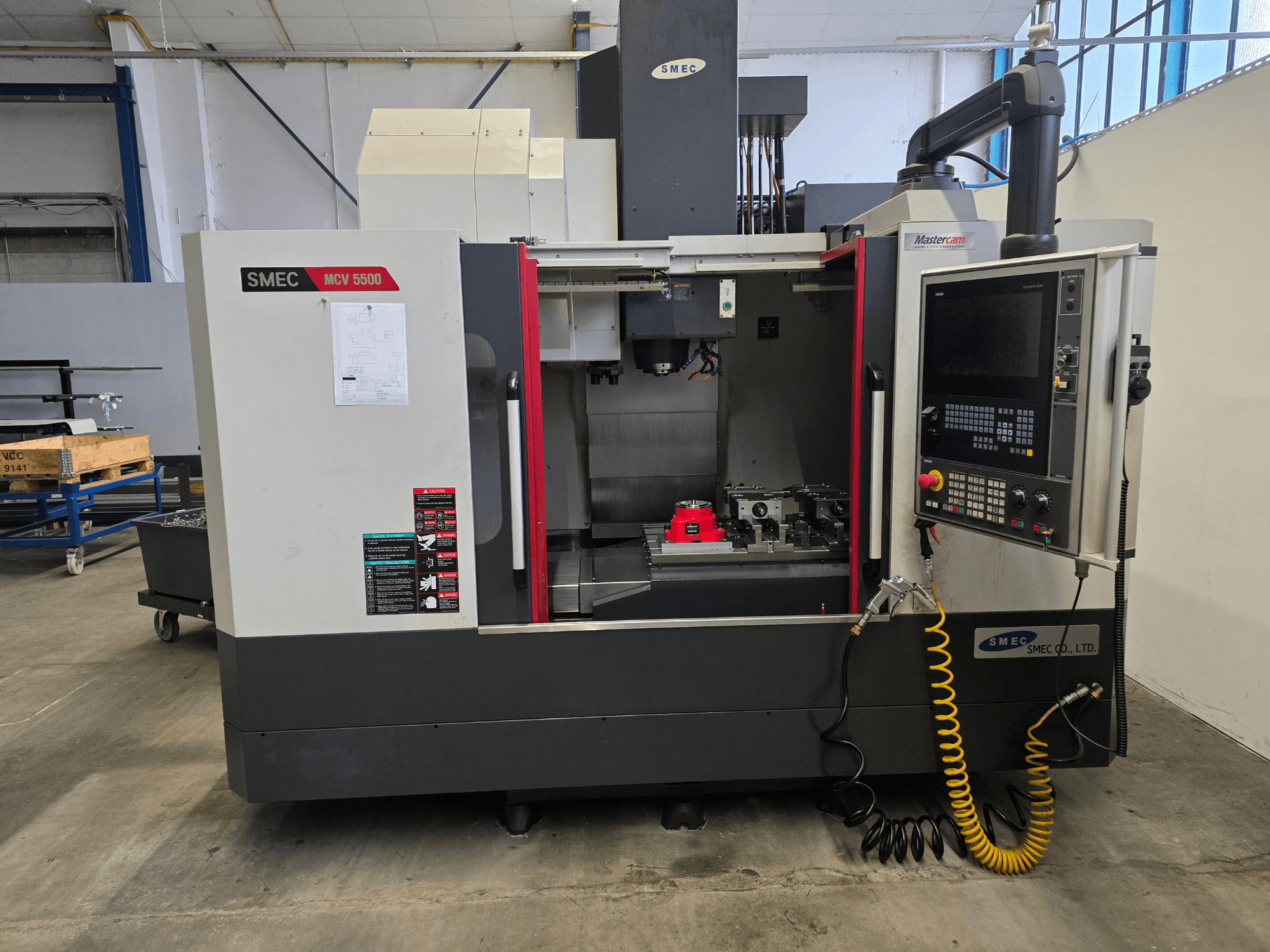 SMEC MCV 5500 dikey işleme merkezi, önden görünüm; kontrol paneli ve takımların bulunduğu makine içi kısım gösterilmektedir.