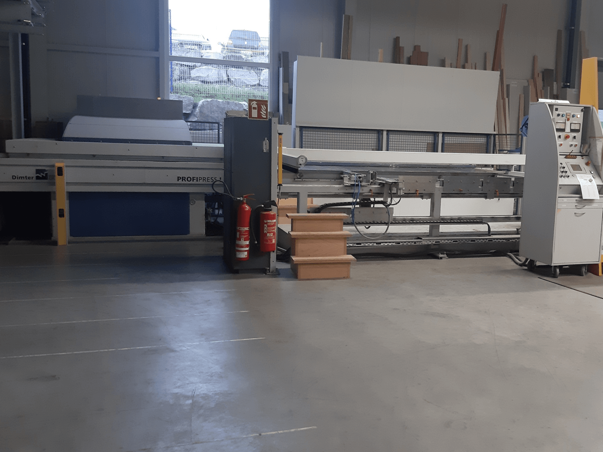 Dimter ProfiPress makinesi bir atölyede, önden bakıldığında, kontrol paneli ve yangın söndürücülerin yanında.