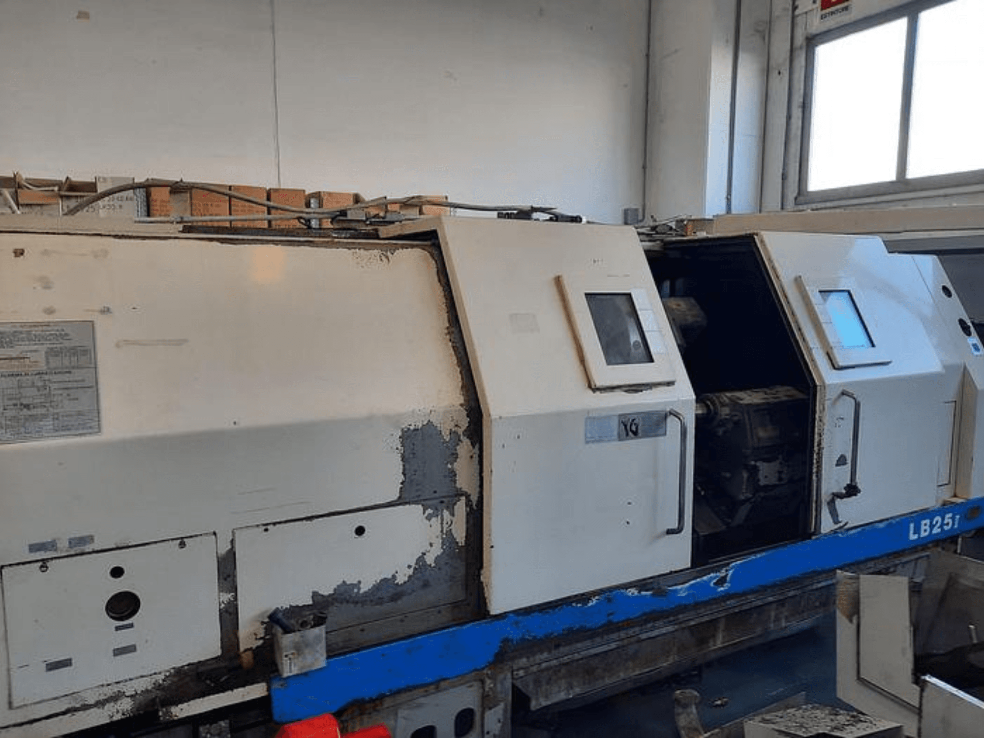 Kullanılmış LB251 torna makinesi, aşınmış dış görünümü gösteren yandan görünüm, iç mekanizmayı ve çalışma kontrollerini ortaya çıkaran açık panel.