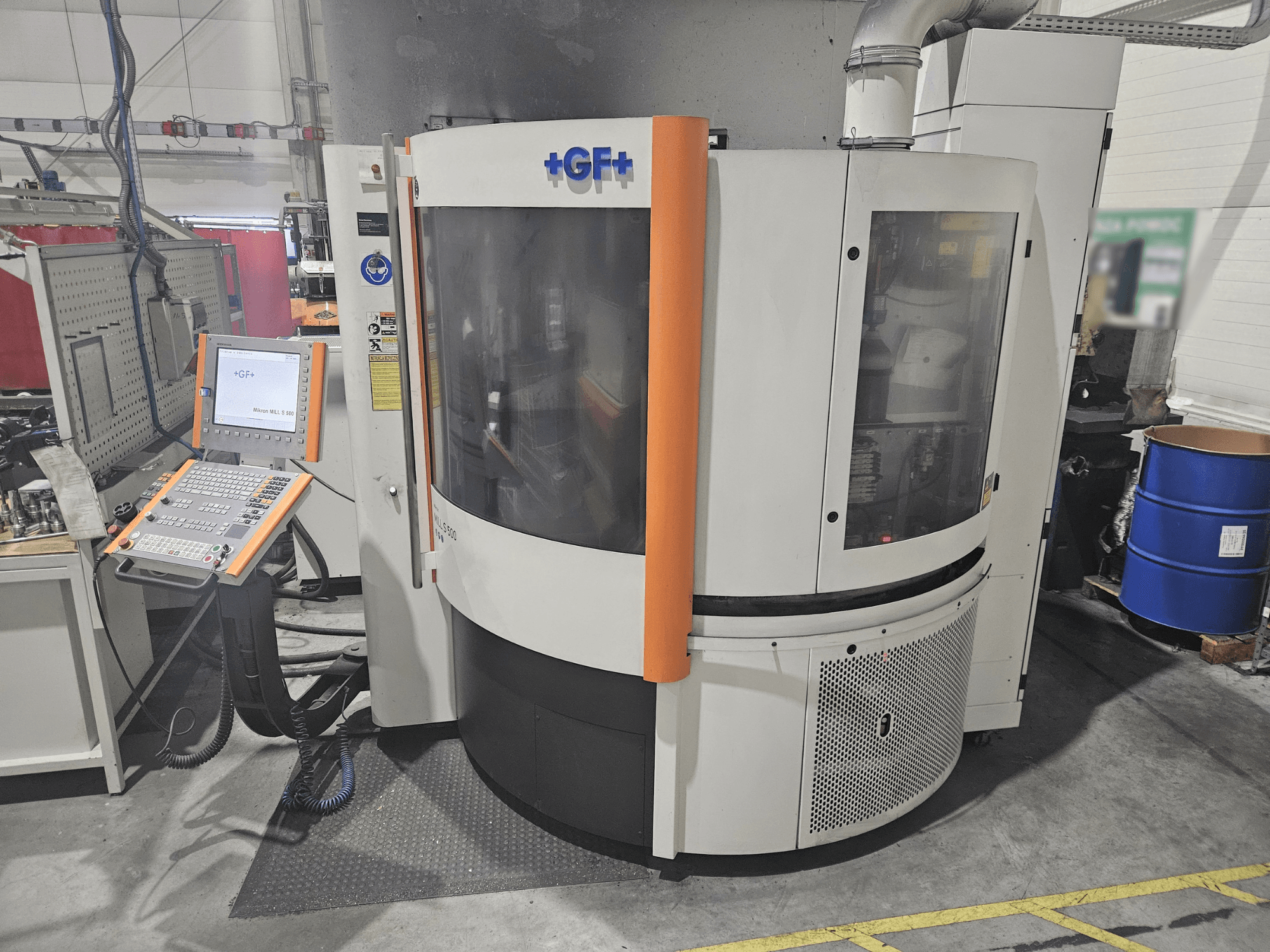 Kontrol panelli GF Machining Solutions takım tezgahı, önden görünüm; şeffaf panel, turuncu vurgular ve endüstriyel ayar özelliklerine sahiptir.