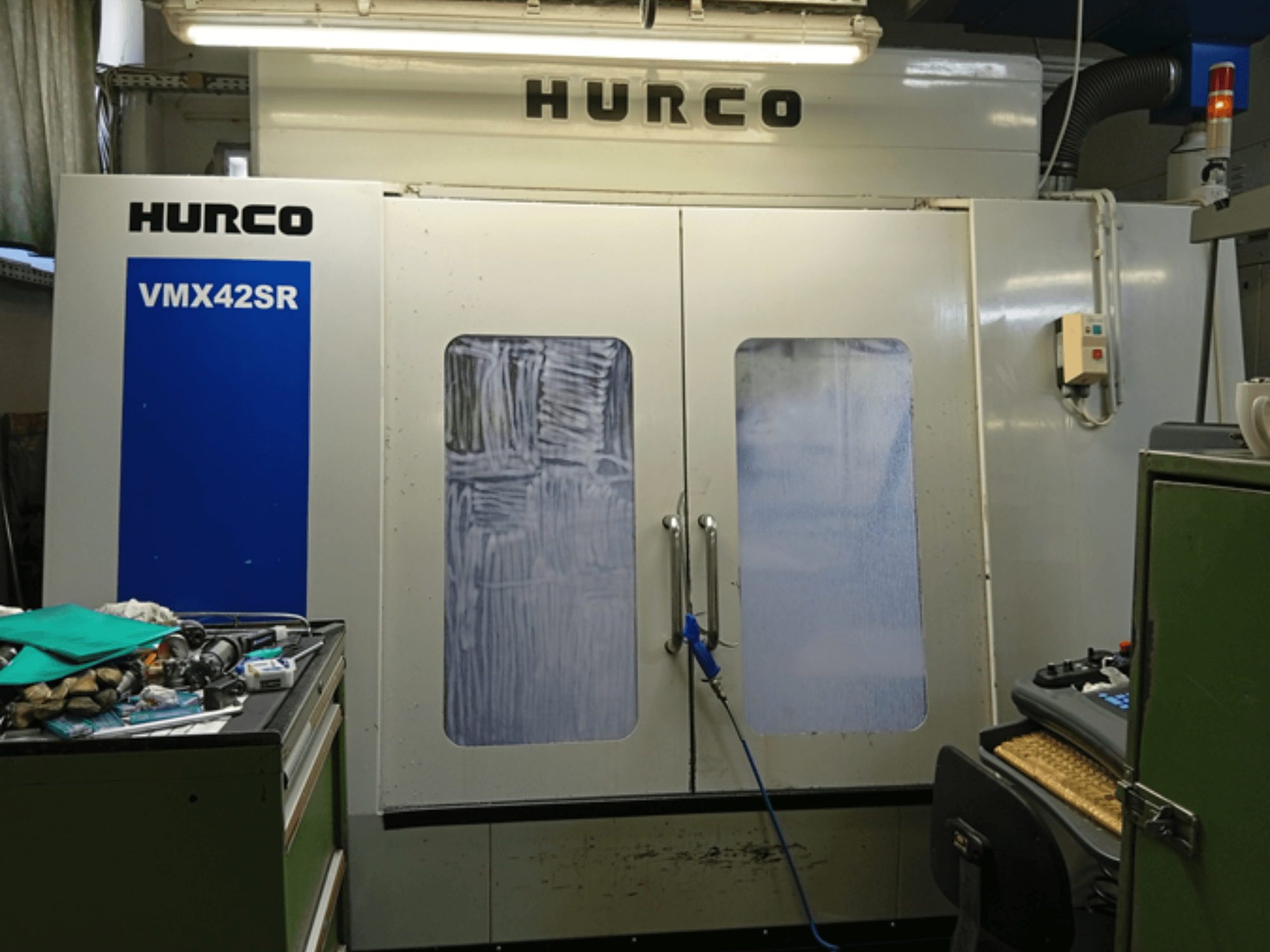 Hurco VMX 42SR dikey işleme merkezinin önden görünümü, mavi panel, kontrol arayüzü ve temiz çalışma alanı.