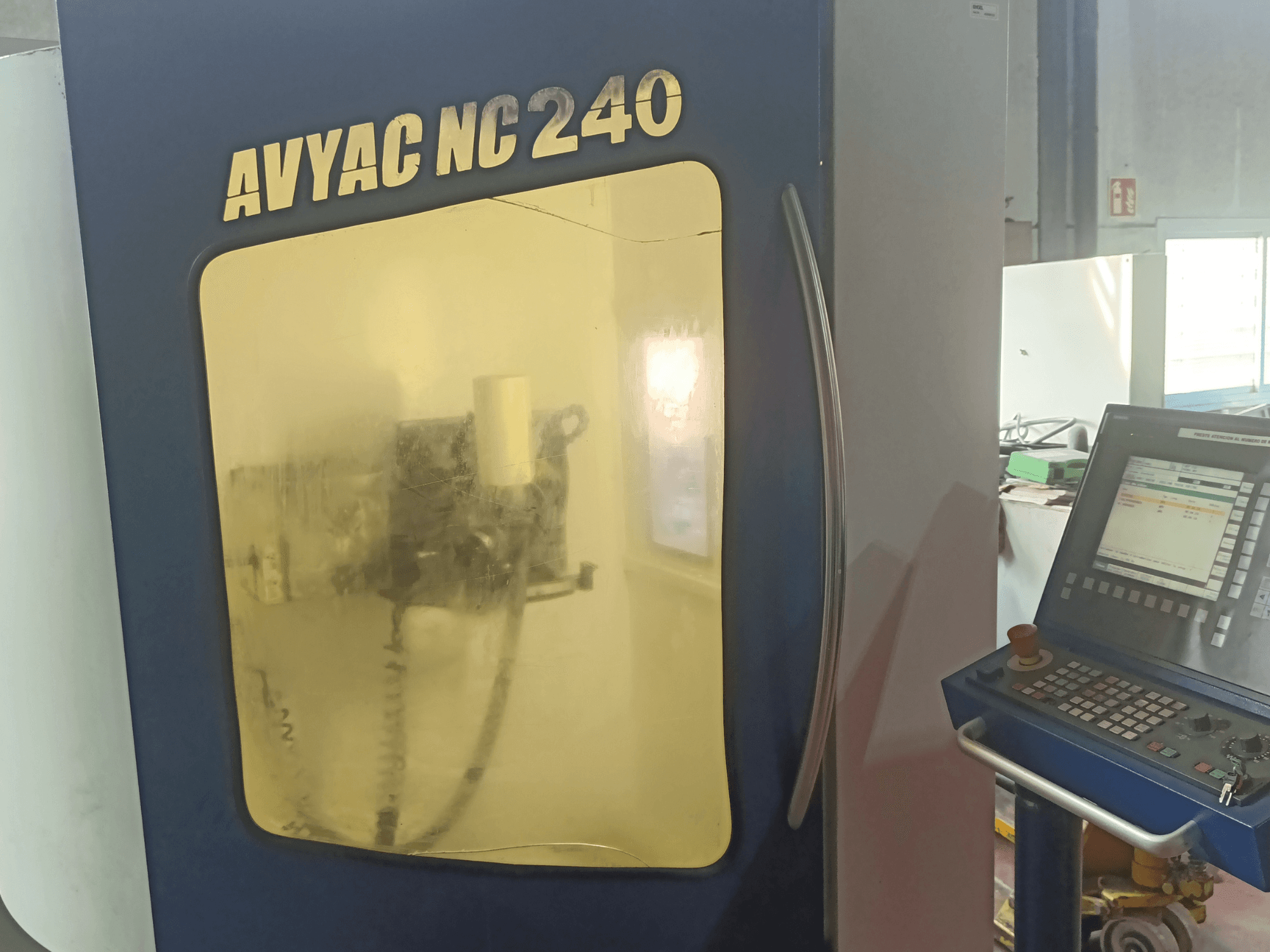 AVYAC NC240 silindirik taşlama makinesi, kontrol panelini ve pencereden kısmen görülebilen taşlama alanını gösteren yandan görünüm.