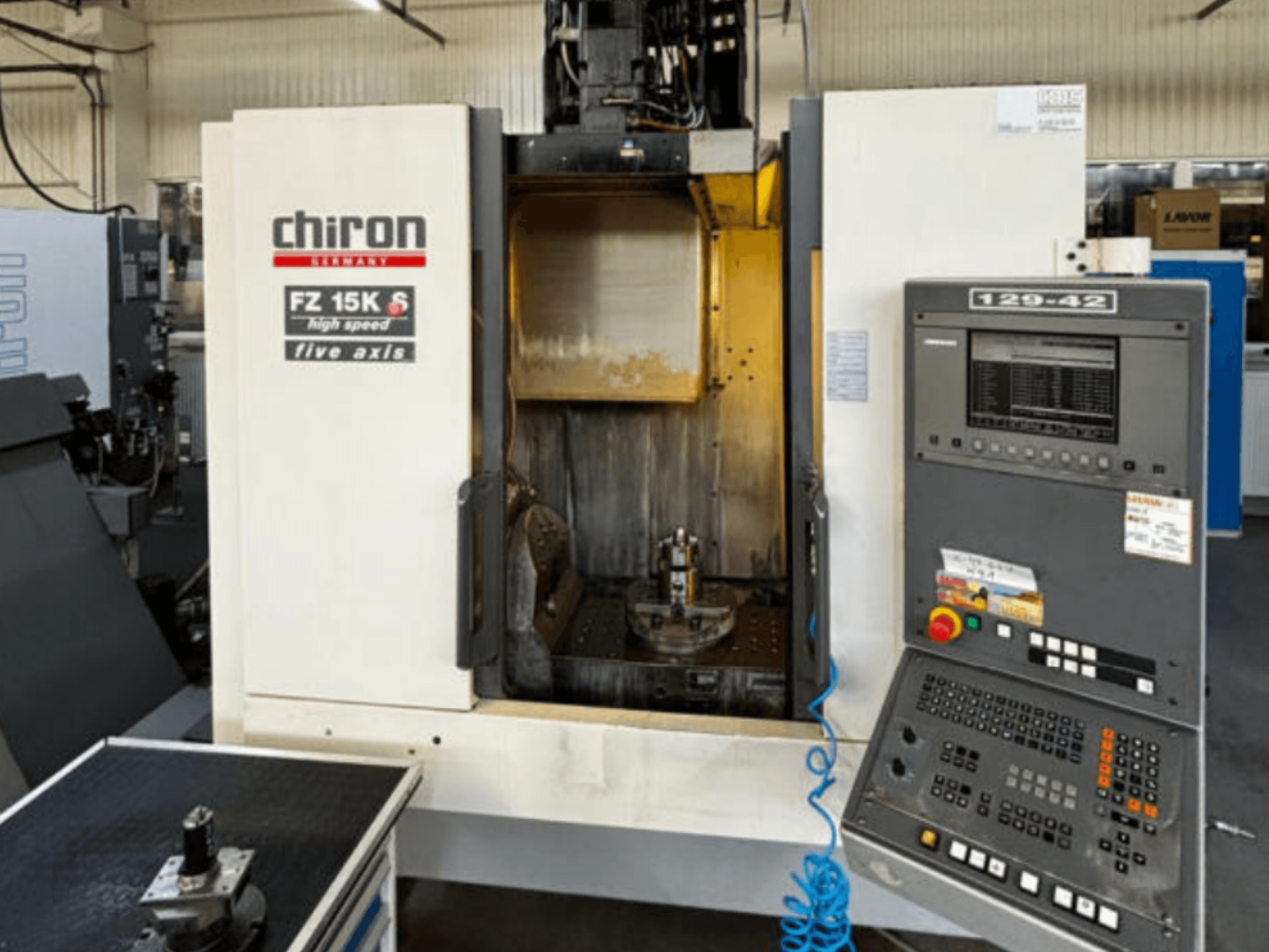 CHIRON FZ 15K S dikey işleme merkezi, önden görünüm; kontrol paneli ve beş eksenli takım düzeni vurgulanmıştır.