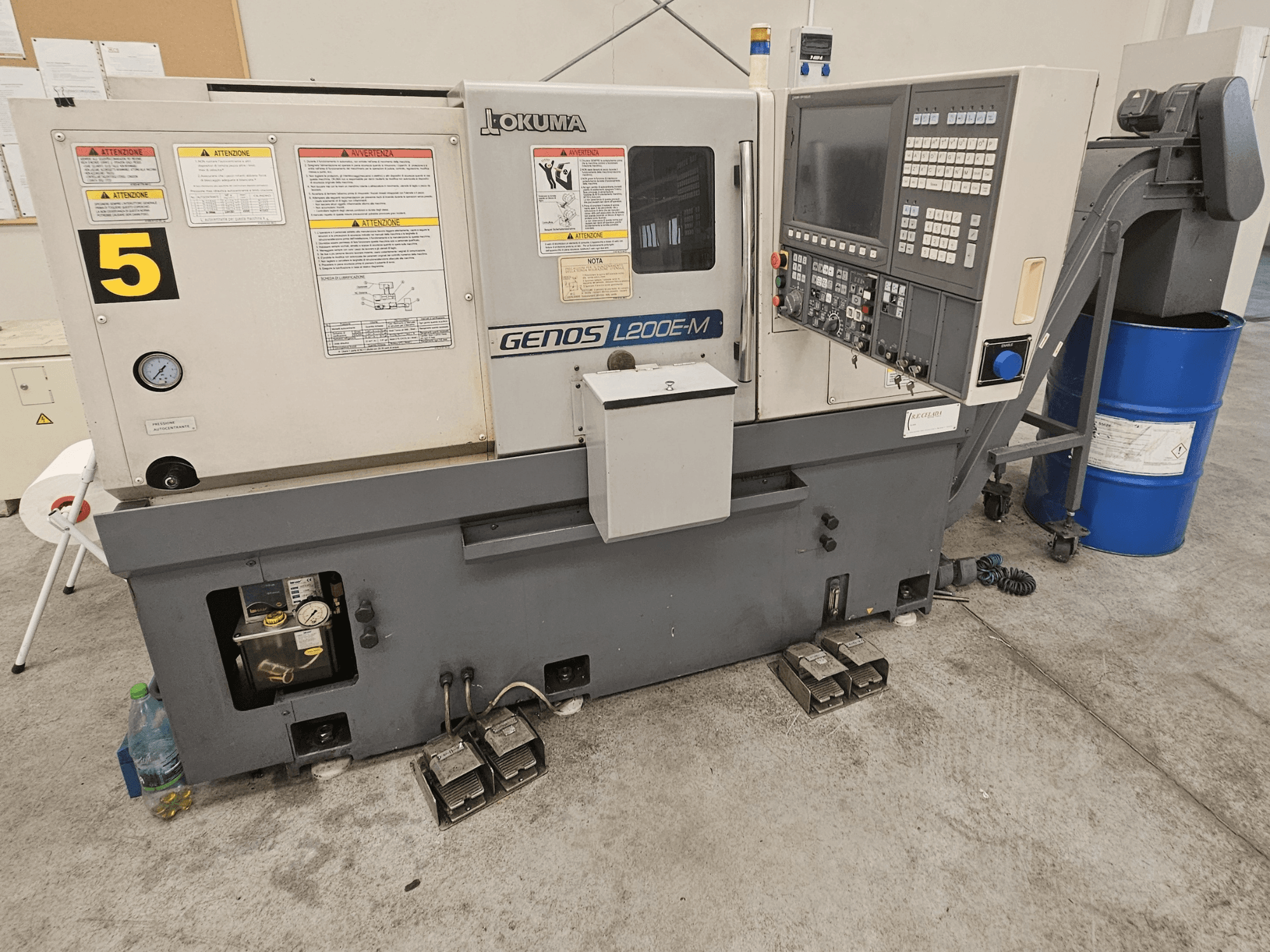 Okuma GENOS L200E-M yatay torna makinesinin önden görünümü, kontrol paneli, etiketler ve soğutma sıvısı kovanı.