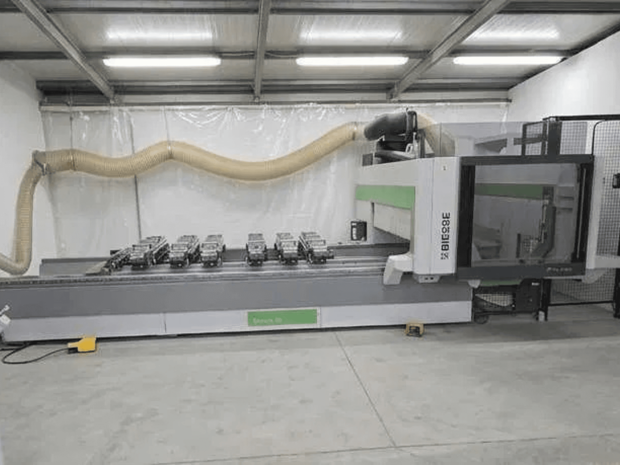 BIESSE Rover K1232 CNC işleme merkezinin yandan görünümü; vakumlu vantuzlar ve toz emme sistemi görülebilir.