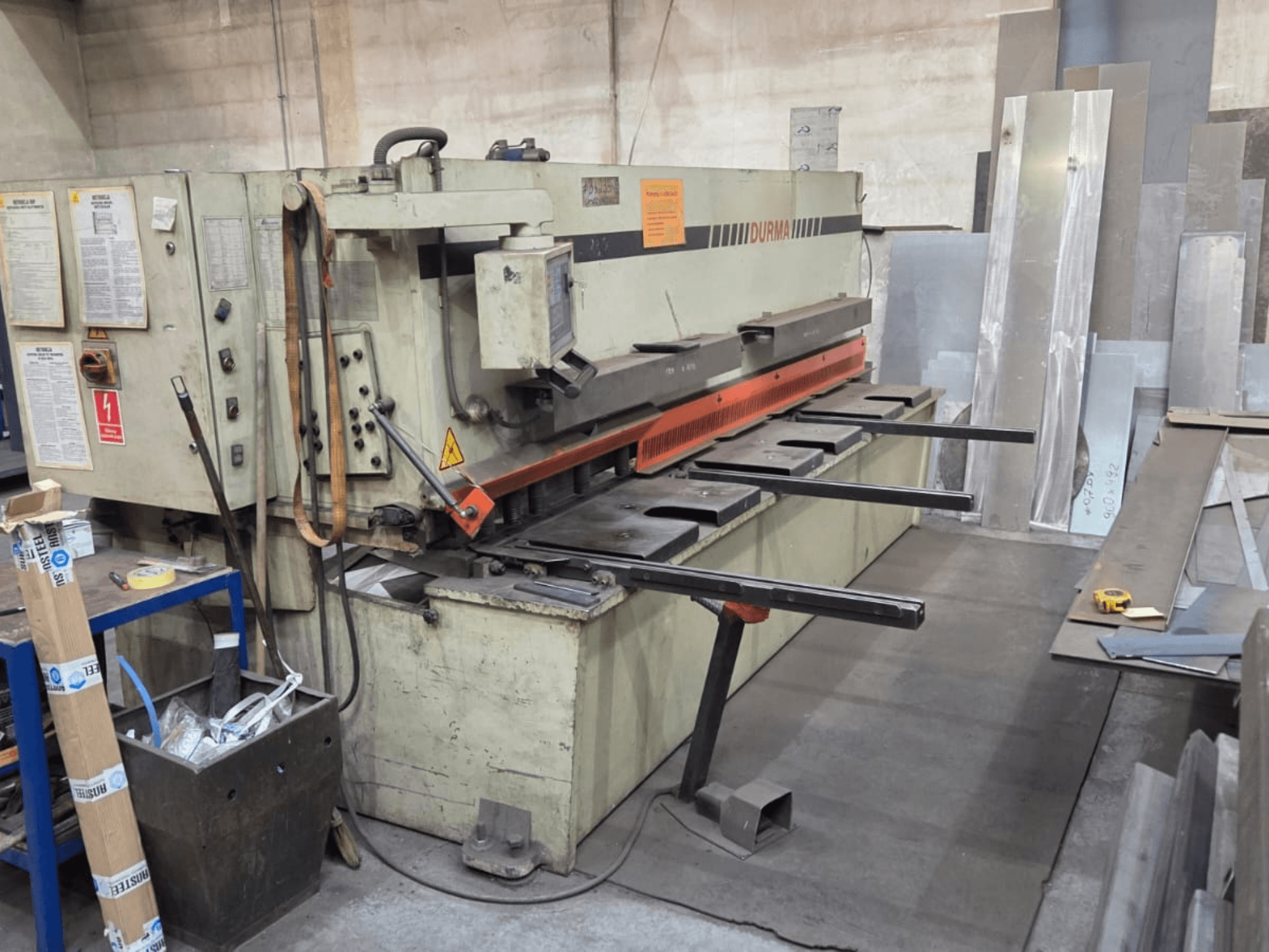 Hidrolik kesme makinesi Durma SB 3060, önden görünüm, kontrolleri, kesme bıçağını ve çalışma alanındaki metal levhaları gösterir.