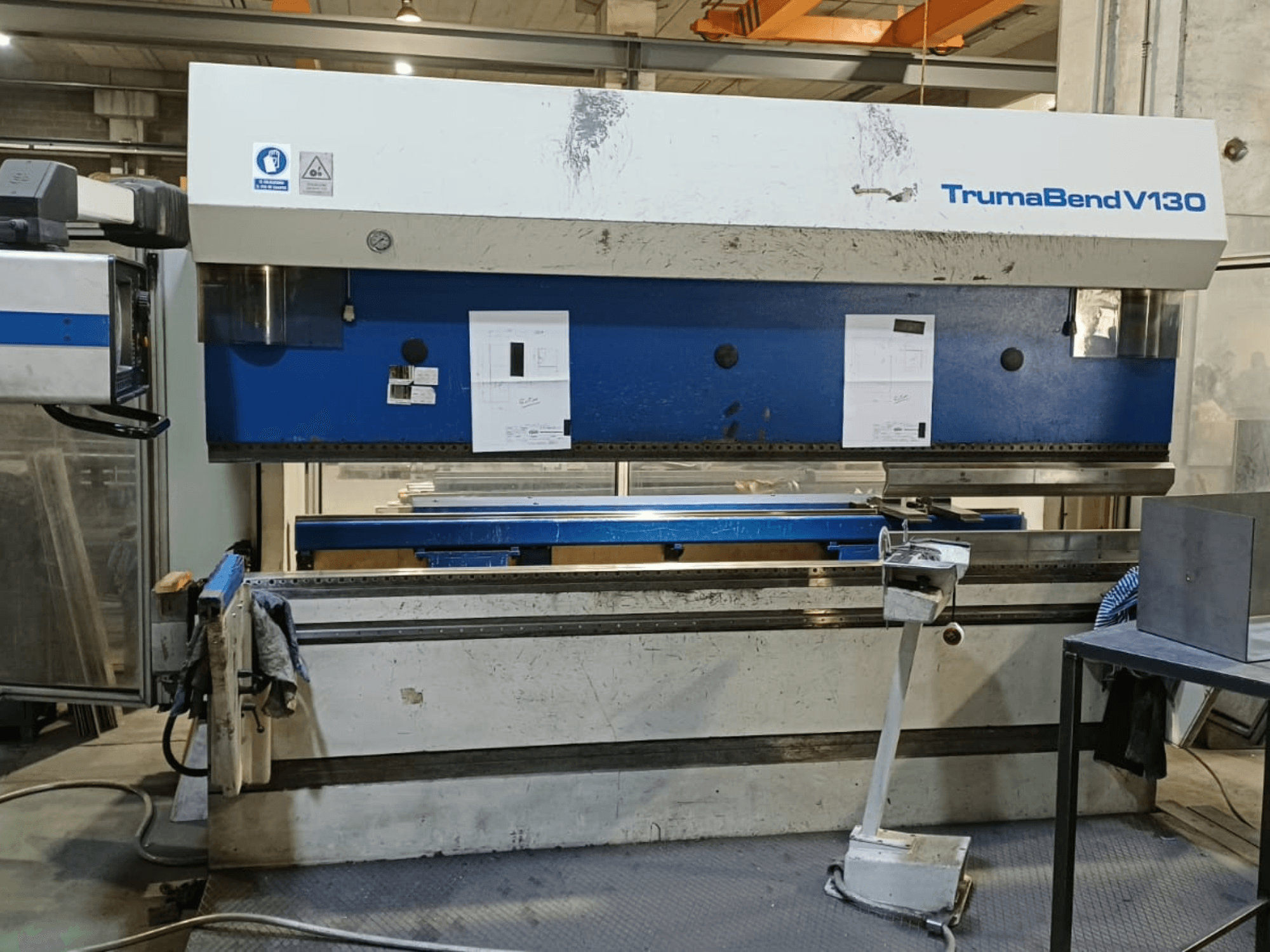 TRUMPF Trumatic Trumabend V130 kant pressinin önden görünümü; kontrol paneli, çalışma yüzeyi ve ayarlanabilir aletler gösterilmektedir.