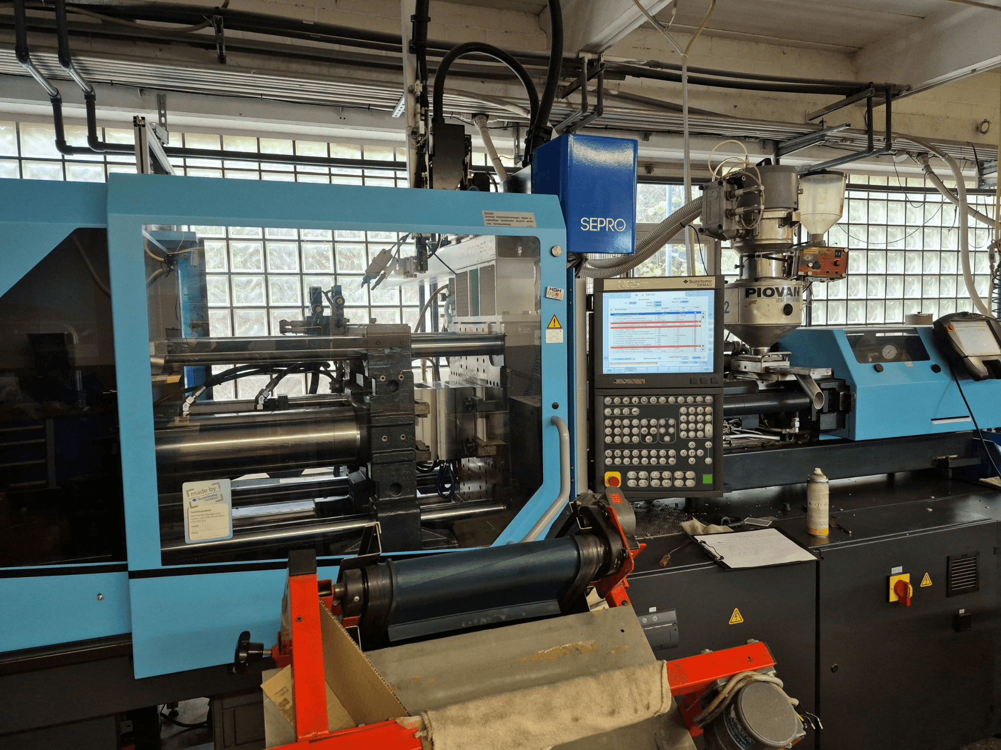 SUMITOMO SHI DEMAG Systec 120/470-430 hidrolik enjeksiyon kalıplama makinesi; kontrol paneli ve besleme sistemi görülebilen önden görünüm.