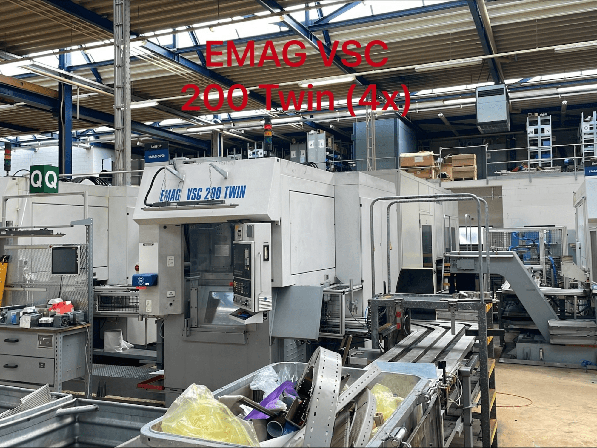Fabrika ortamında EMAG VSC 200 TWIN dikey tornalama makinesi, kontrolleri ve takım depolama alanını gösteren önden görünüm.