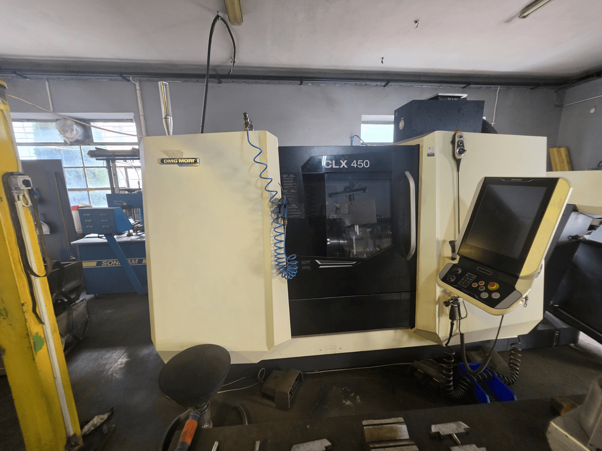 DMG MORI CLX 450 V6 yatay torna tezgahının önden görünümü; kontrol paneli ve açıkça görülebilen marka logosu ile birlikte.