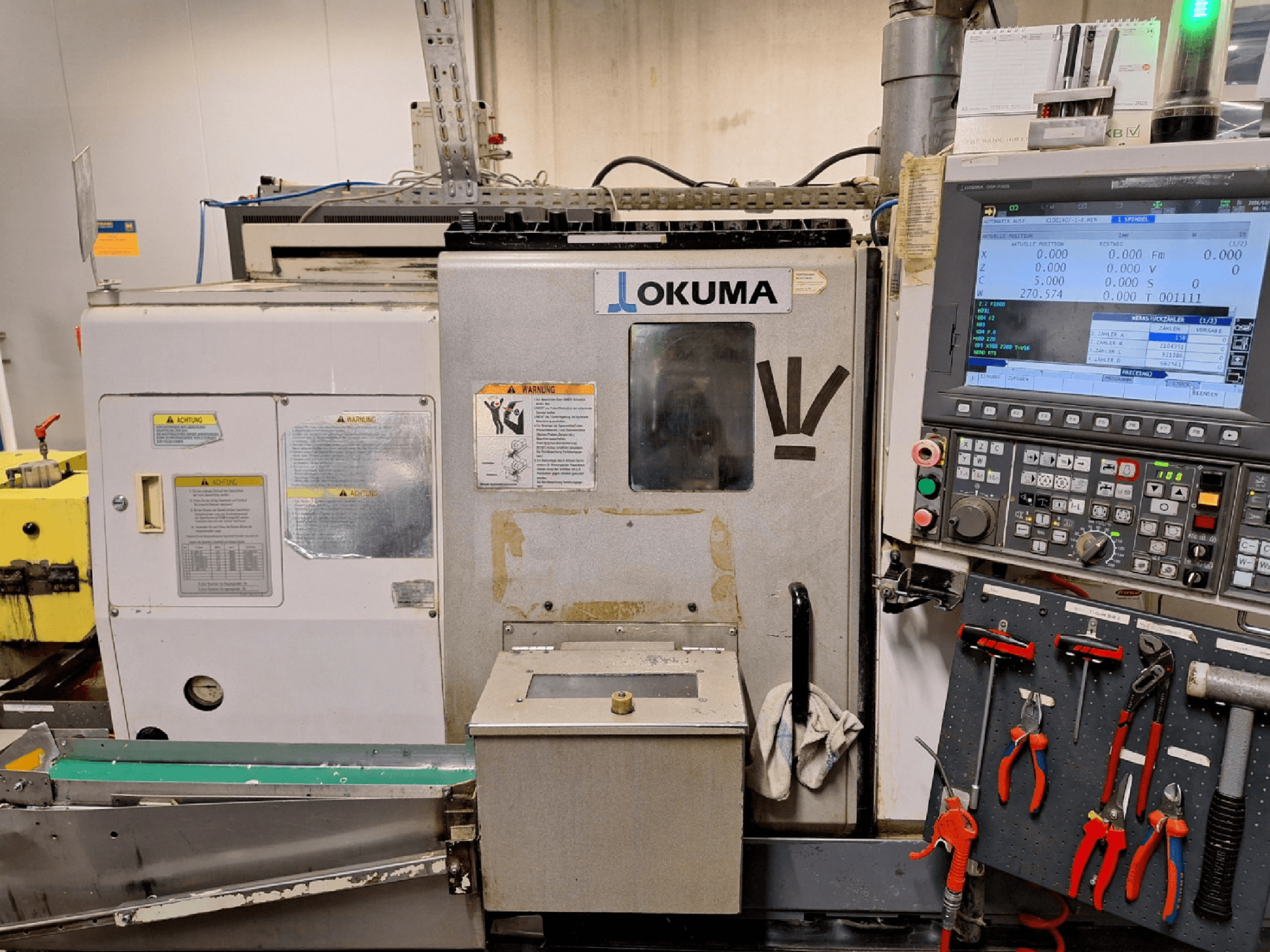 Okuma LB200-MW yatay torna tezgahı, önden görünüm; yan tarafta kontrol paneli ve takımlar görülüyor.