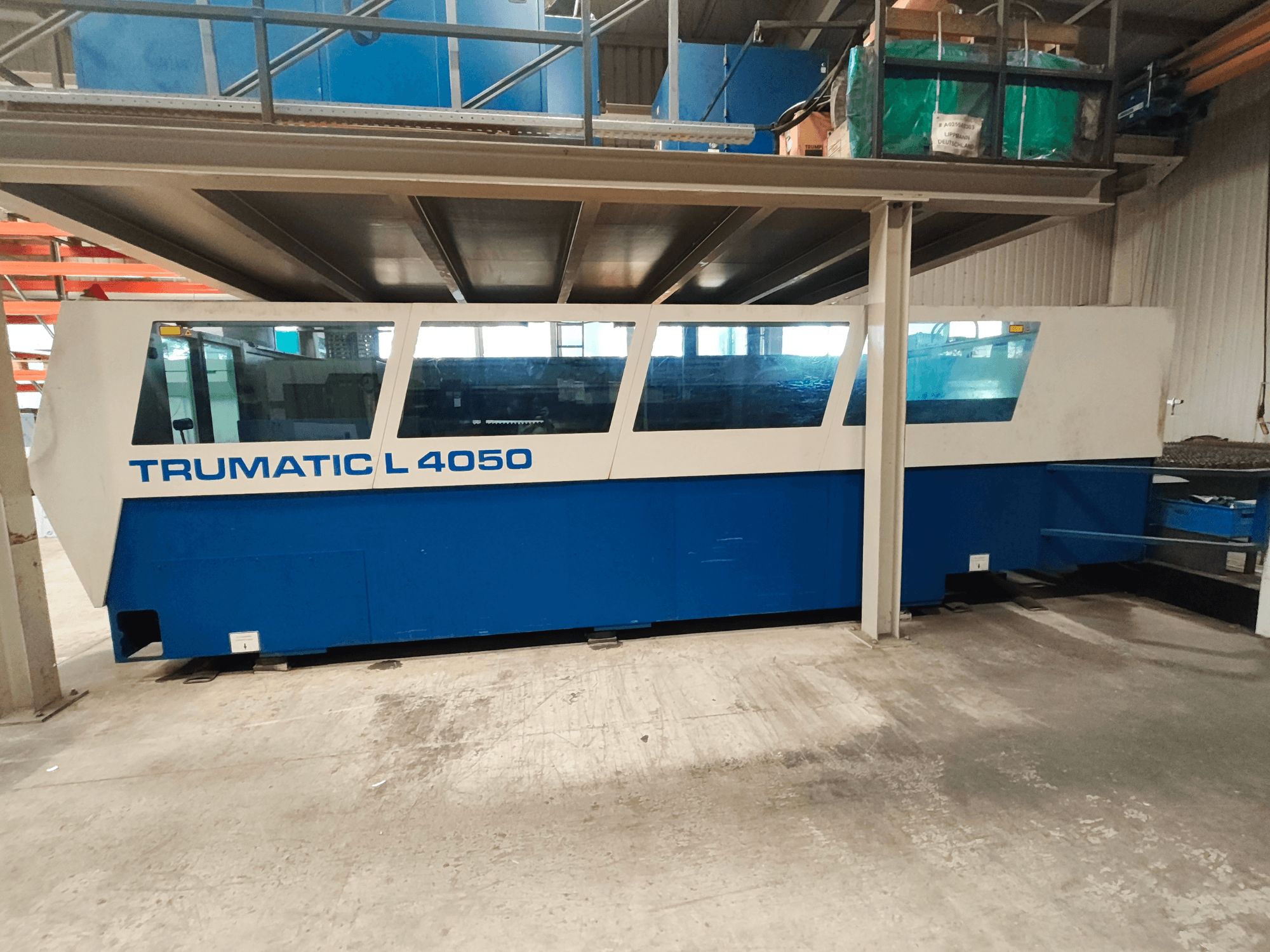 Mavi ve beyaz renkli tasarıma sahip, kontrol paneli ve çalışma alanı açıkça görülebilen TRUMPF TruLaser 450 CO₂ lazer kesim makinesinin yandan görünümü.