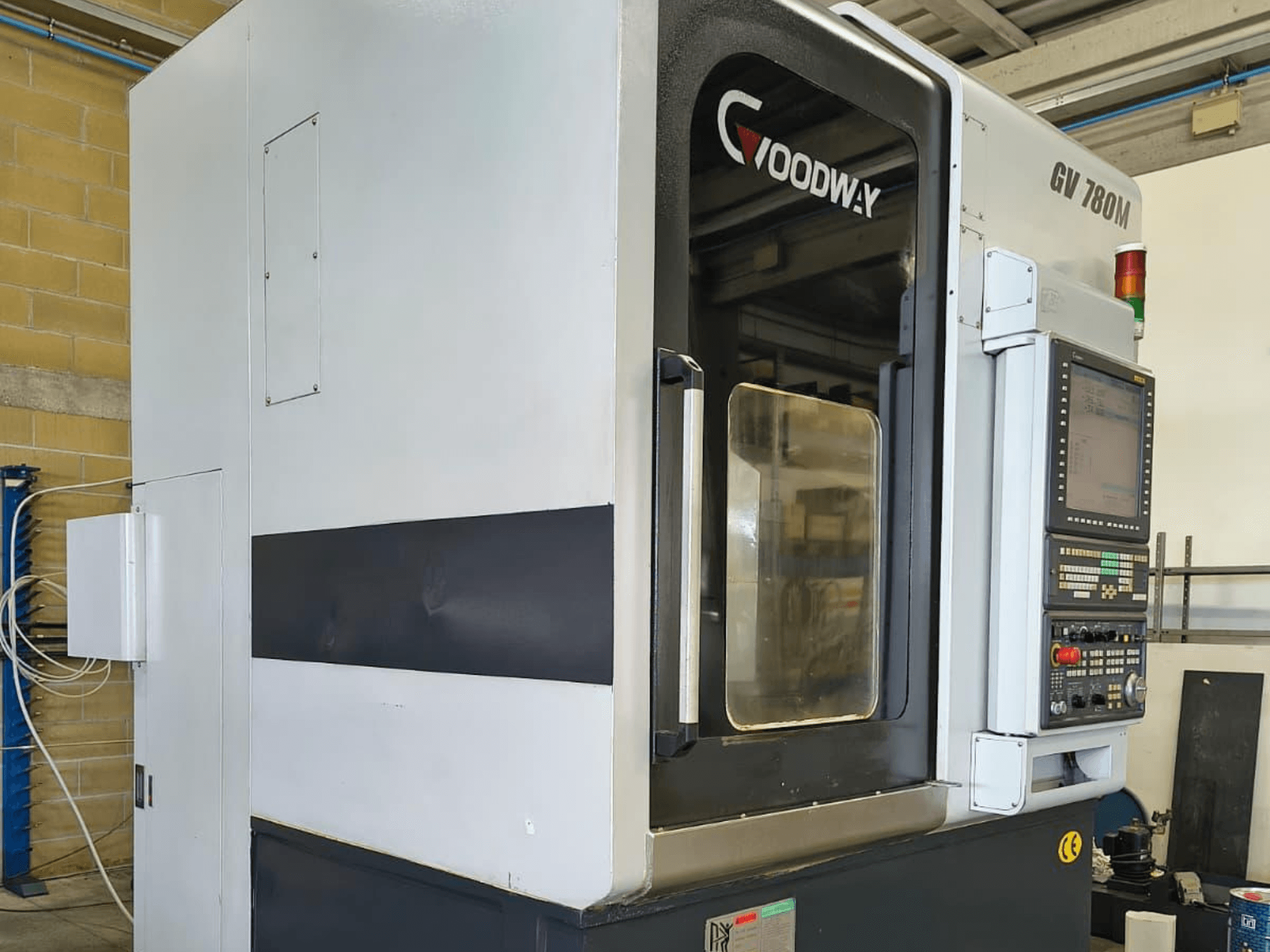 Goodway GV 780 M dikey torna makinesi, yandan görünüm, kontrol paneli, güvenlik özellikleri ve temiz dış tasarımı sergiliyor.