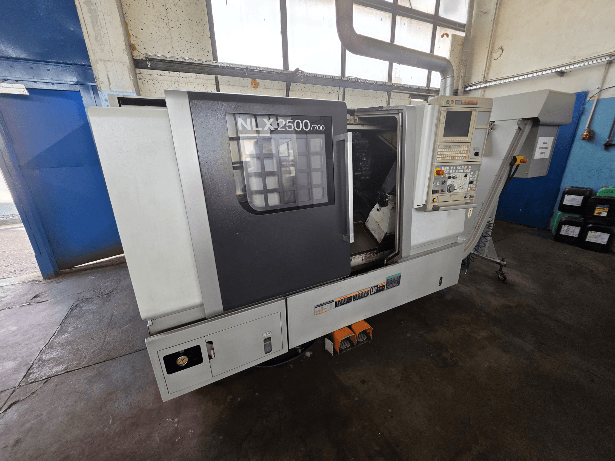 DMG MORI NLX 2500/700 yatay torna tezgahının yandan görünümü; kontrol paneli ve işleme alanı açıkça görülmektedir.