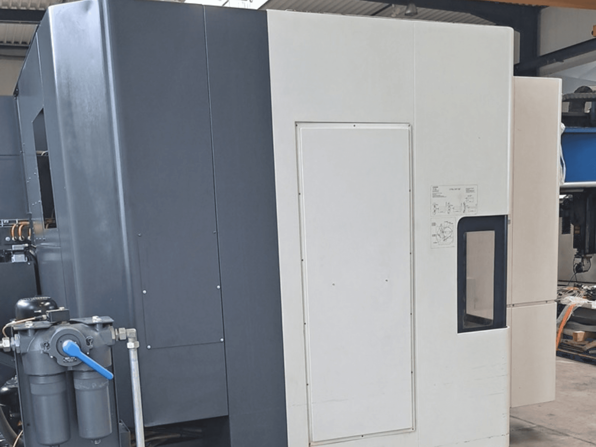 DMG MORI NHX5000 yatay işleme merkezi; kontrol paneli ve mekanik özellikleri gösteren yan görünüm.