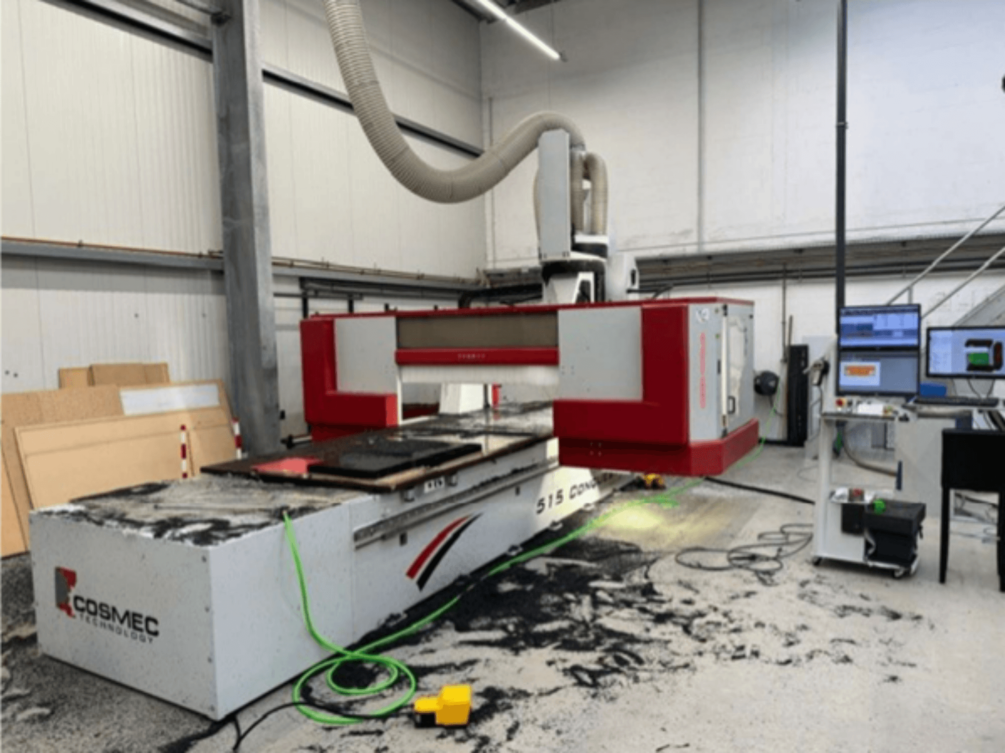 Cosmec 515 CNC makinesi, bir bilgisayar terminali ile atölyede, önden görünüm ve yüzeye dağılmış tozu gösteriyor.