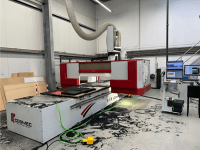 Cosmec 515 CNC makinesi, bir bilgisayar terminali ile atölyede, önden görünüm ve yüzeye dağılmış tozu gösteriyor.