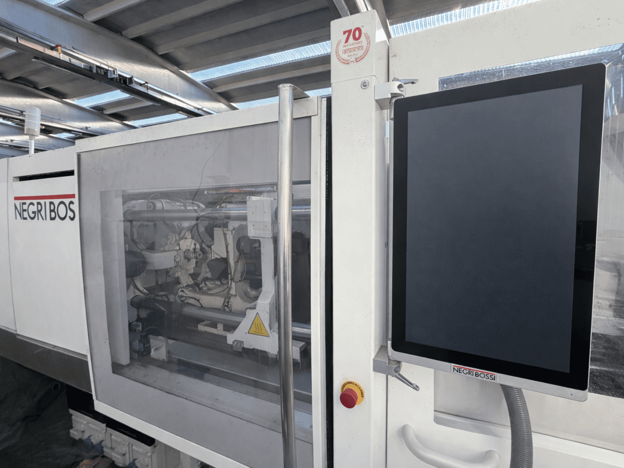 Negri Bossi ELE 80 elektrikli enjeksiyon kalıplama makinesi, kontrol ekranı ve görünür iç bileşenleri ile önden görünüm.