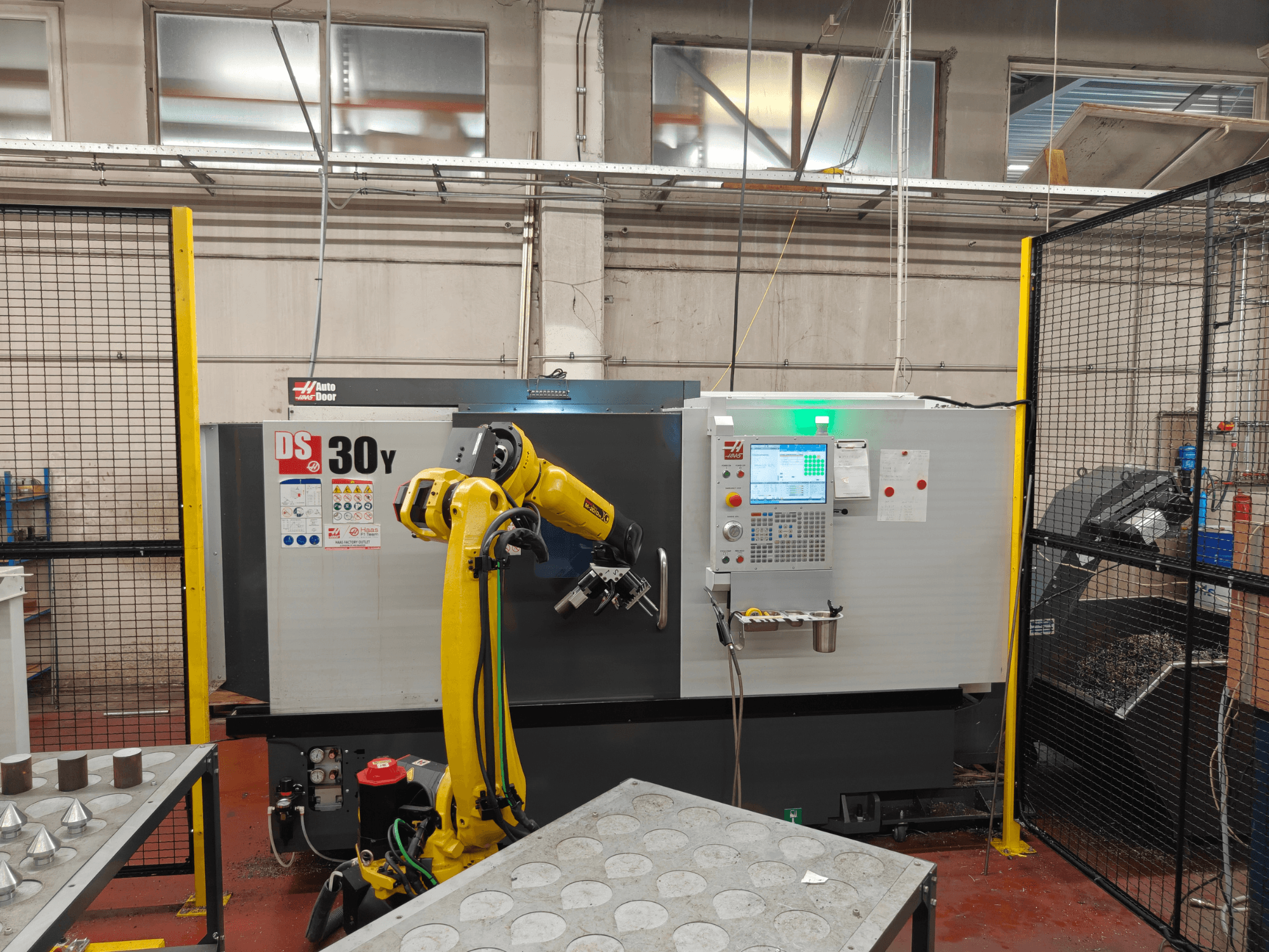Robot kolu bulunan HAAS DS30Y yatay torna tezgahı, önden görünüm; kontrol paneli ve çalışma alanı gösterilmektedir.