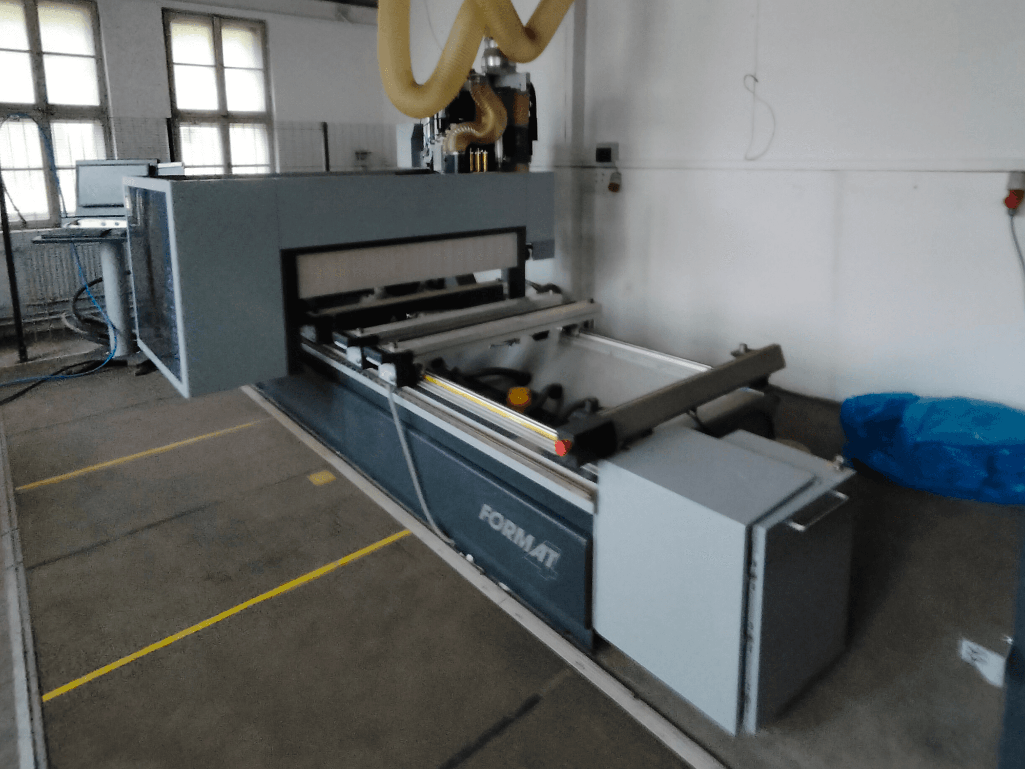 Kılavuz raylar ve görünür bir kontrol paneli içeren gri gövdeli bir Format CNC makinesinin önden görünümü.