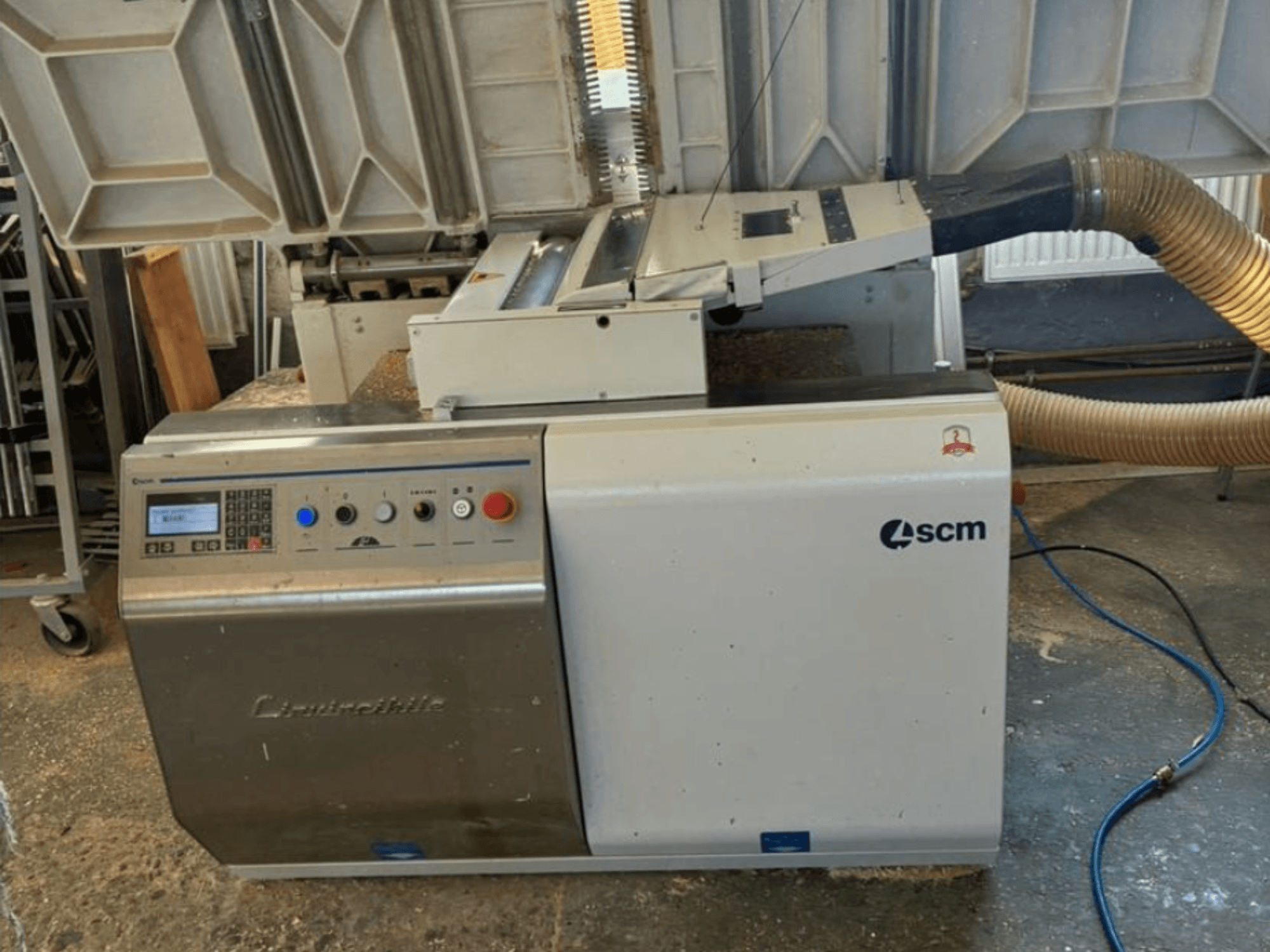 SCM Centauro kenar bantlama makinesinin önden görünümü, kontrol panelini, emme hortumunu ve kenar uygulaması için açık çalışma alanını gösterir.