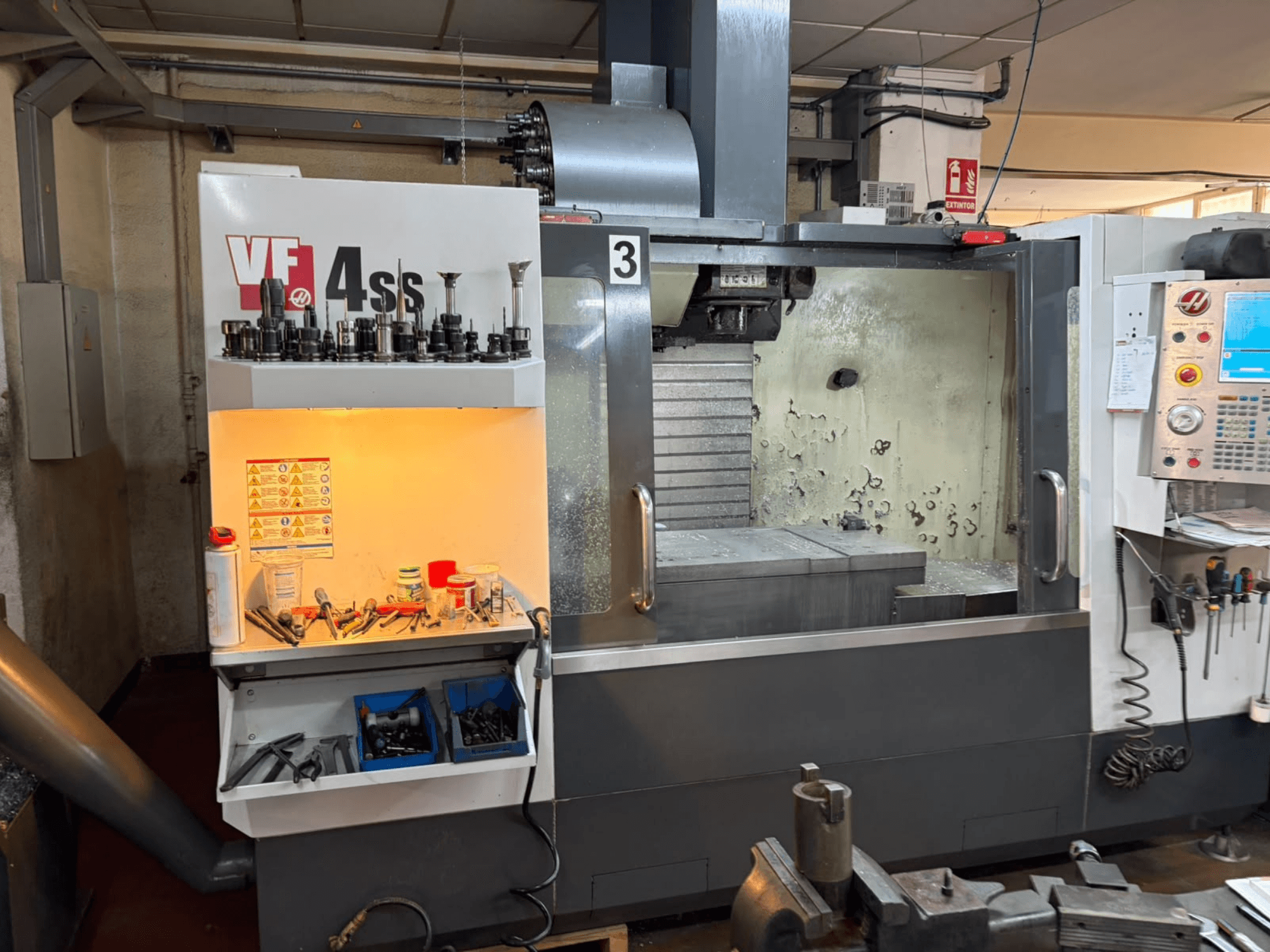 HAAS VP 4SS dikey işleme merkezi, önden görünüm; takım depolama bölmesi, kontrol paneli ve işleme detaylarının görülebildiği işleme alanı.