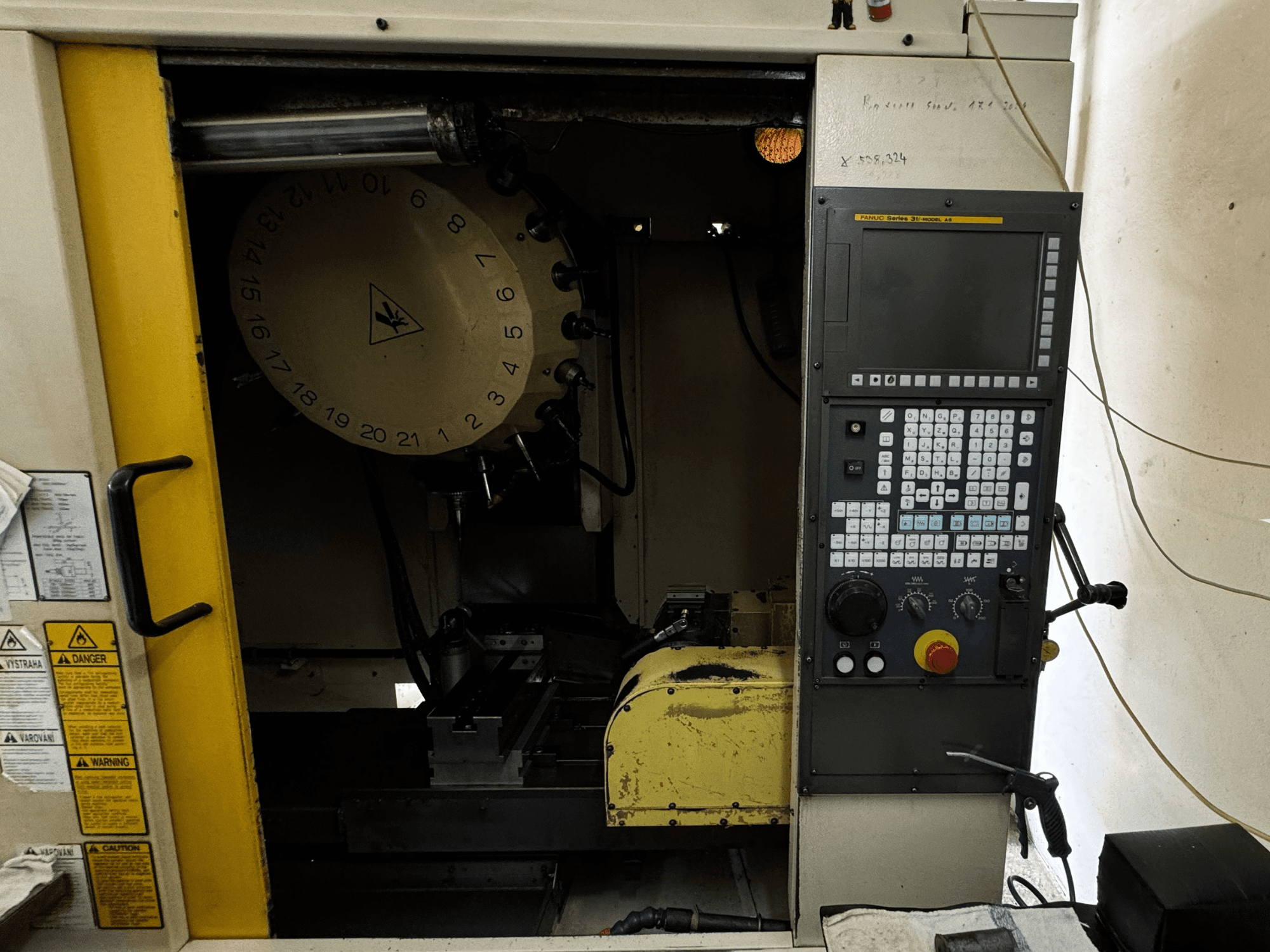 FANUC Robodrill alpha-T21iFL dikey işleme merkezi, kontrol panelini ve takım magazinini gösteren önden görünüm.