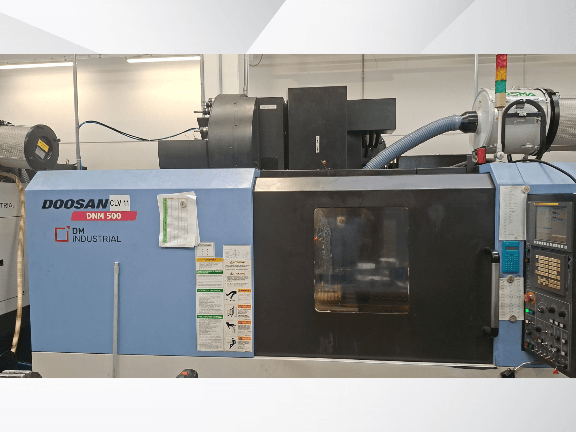 DOOSAN DNM 500 Dikey İşleme Merkezi’nin yandan görünümü; kontrol paneli ve çalışma parçaları görülmektedir.