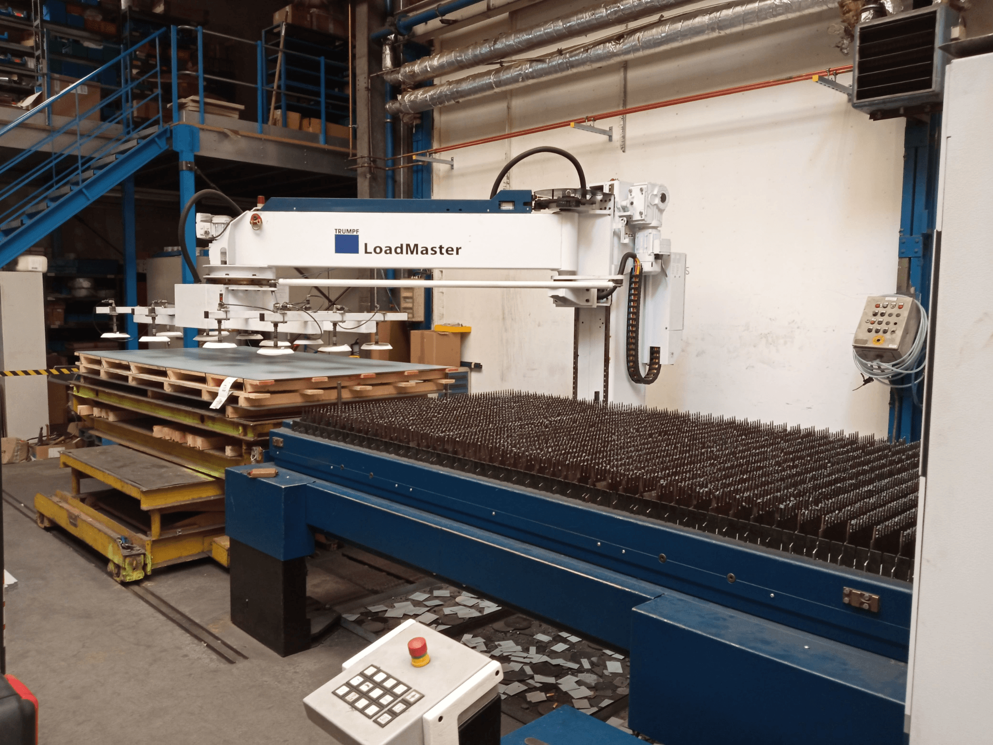 TRUMPF TruLaser 3030 CO₂ lazer kesim makinesinin yandan görünümü; LoadMaster ve malzeme paletleri de görülmektedir.