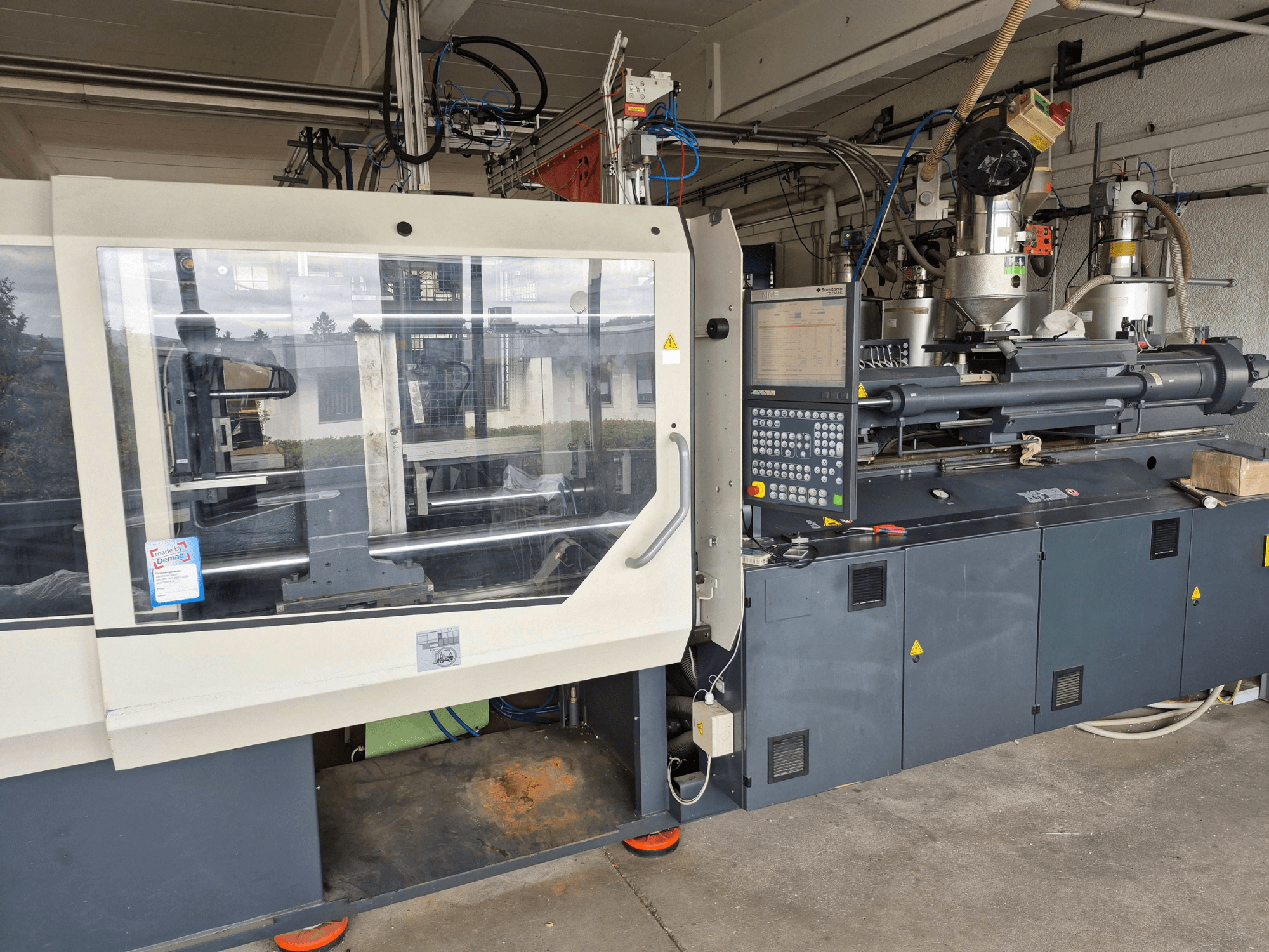 Hidrolik Enjeksiyon Kalıplama Makinesi, SUMITOMO SHI DEMAG Systec 210/580-1450, kontrol paneli ve görünür bileşenleri ile birlikte önden görünüm.