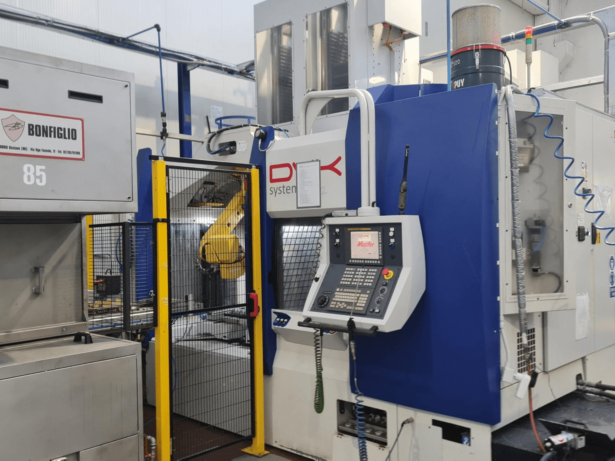 DVK System Master yatay işleme merkezi, önden görünüm; kontrol paneli, güvenlik kapısı ve robot kolu ile birlikte.