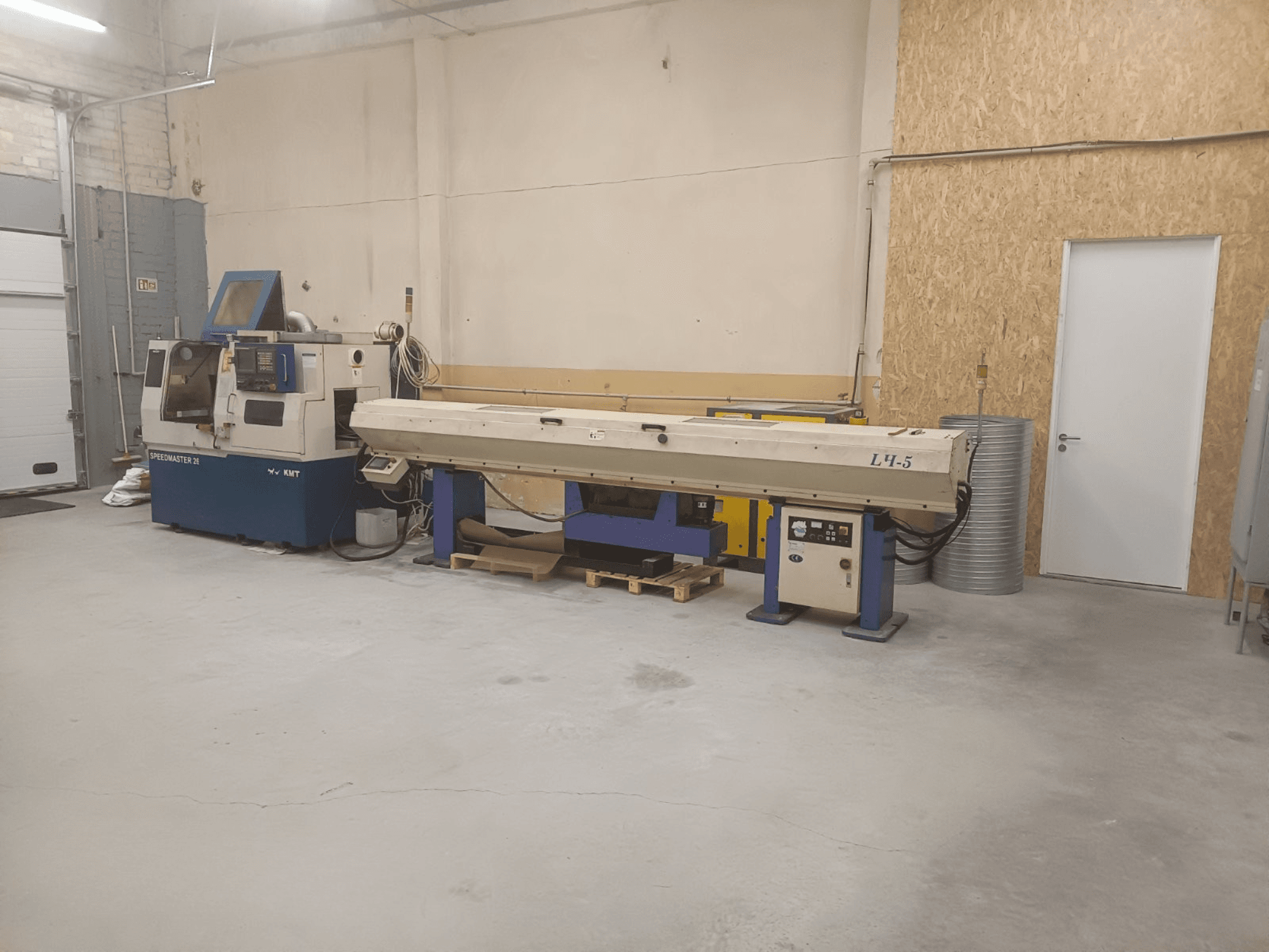 KMT Speedmaster 34 makinesi ve L4.5 içeren endüstriyel atölye, önden bakıldığında, görünür kontroller ve makineler.
