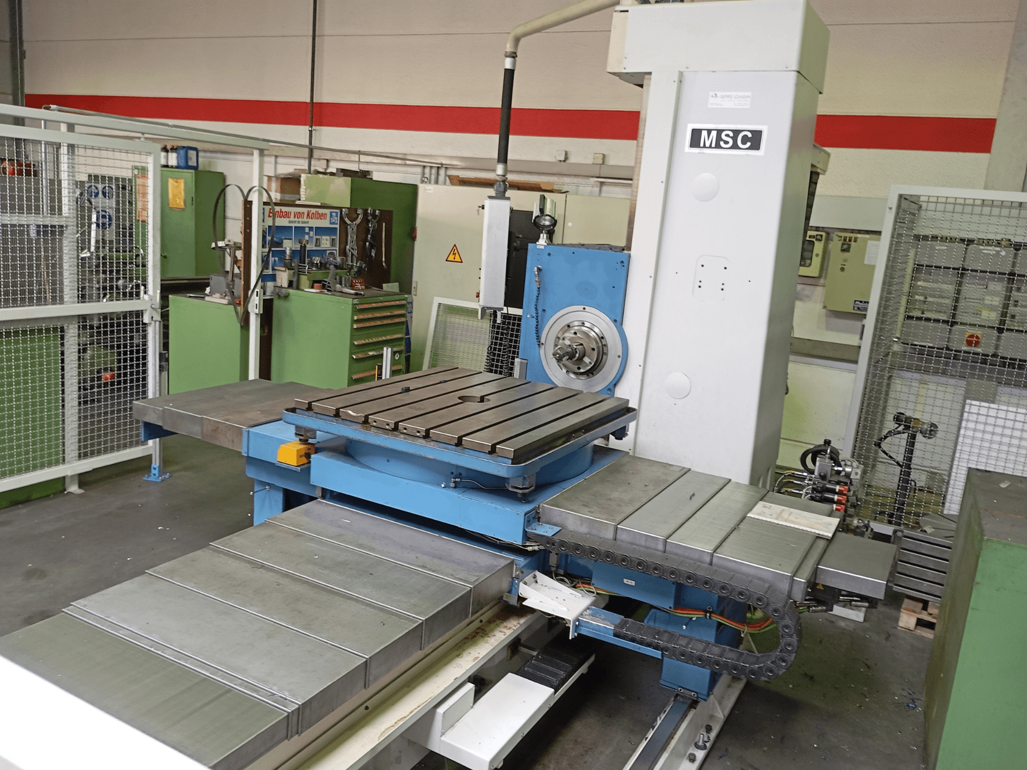 MSC BFT 90/5 TNC 320 delme makinesi, yandan görünüm; bir atölye ortamında metal bir çalışma masası ve takım tutucusuna sahiptir.