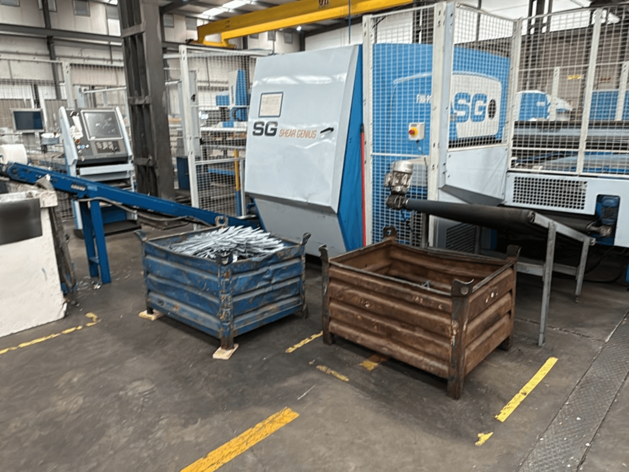 Finn-Power SG6 12.61 delme ve bükme makinesi, atölye ortamında yanında metal konteynerler ile önden görünüm.
