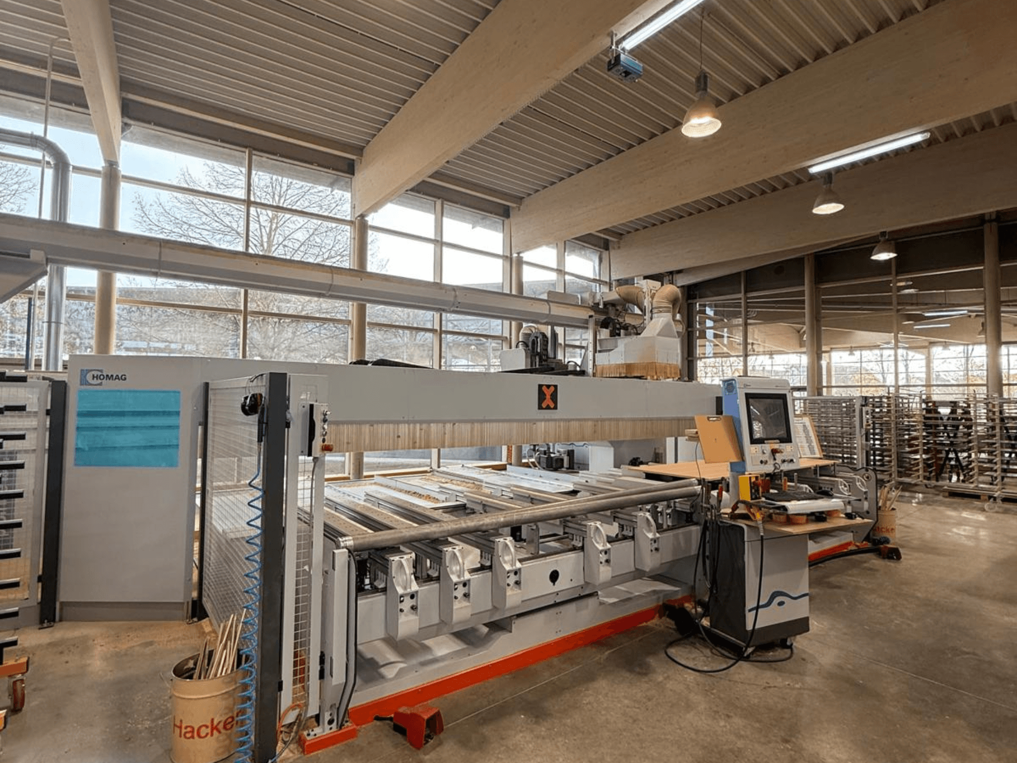 Bir atölyede HOMAG CNC makinesi, önden görünüm, hassas ahşap işleme için bir kontrol paneli ve çoklu takım yuvaları sergiliyor.