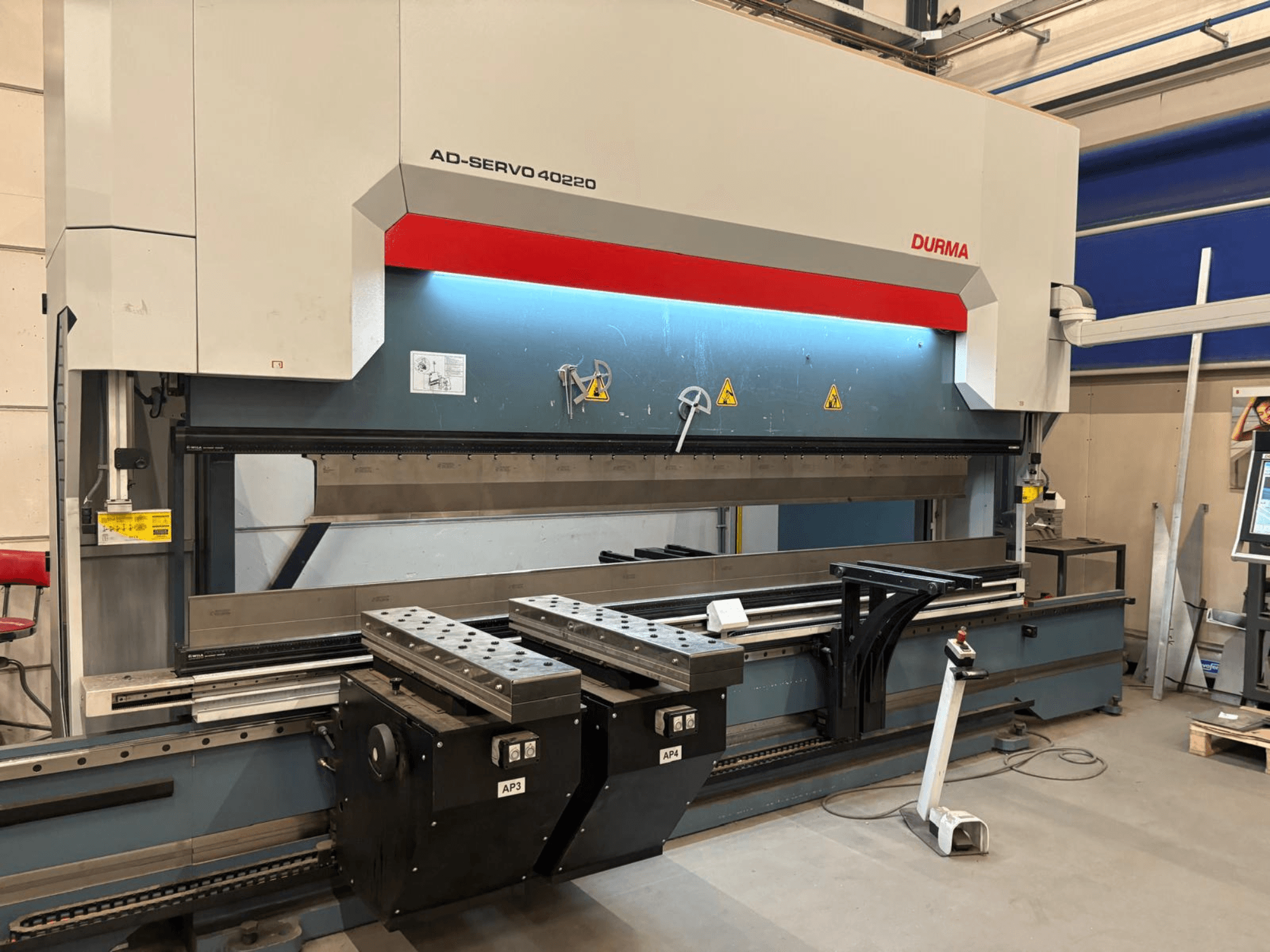 Durma AD-SERVO 40220 kant press, önden görünüm; kontrol paneli, hidrolik sistem ve iş masası üzerindeki kalıplar gösterilmektedir.