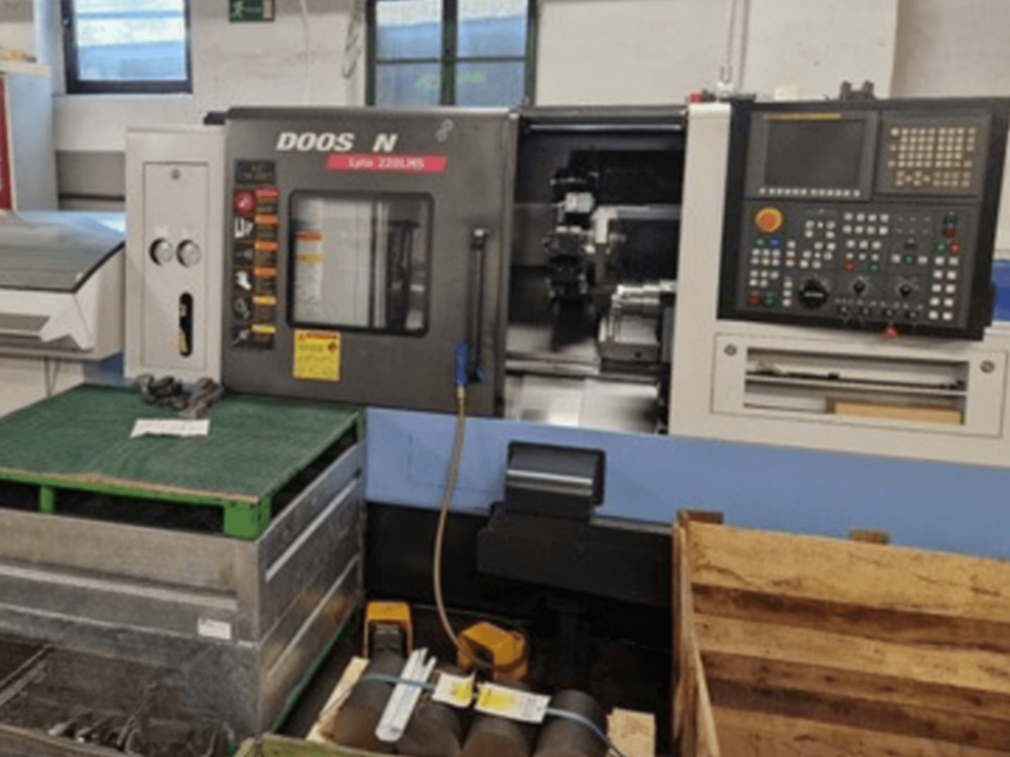 DOOSAN Lyax 220 LMS yatay tornalama makinesinin önden görünümü, kontrol paneli, takımlar ve çalışma alanı.
