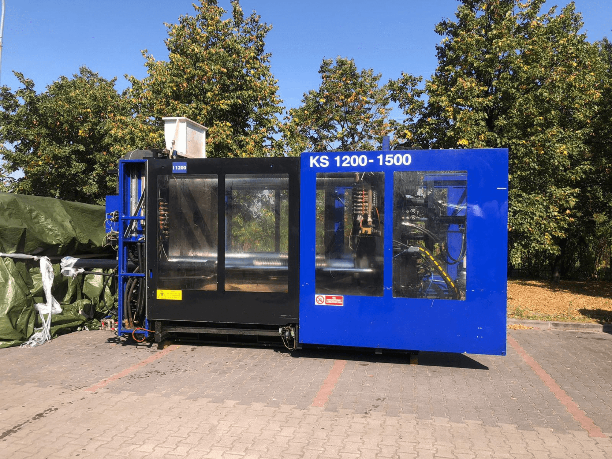 Hidrolik Enjeksiyon Makinesi ITALTECH KS 1200 8300 ES, yandan görünüm, bir park ortamında kontrolleri ve makine detaylarını sergiliyor.