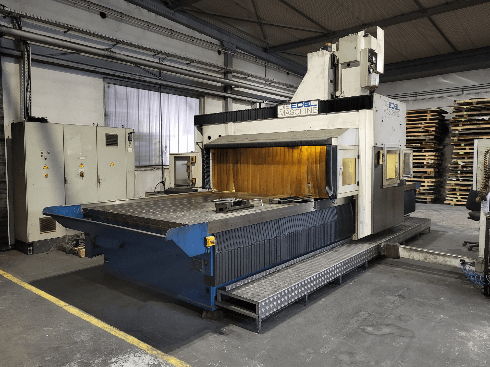 Gantry Freze Makinesi EDEL Koordimatic XL 4020, önden görünüm, endüstriyel ortamda büyük çalışma tezgahını ve kontrol ünitesini gösterir.