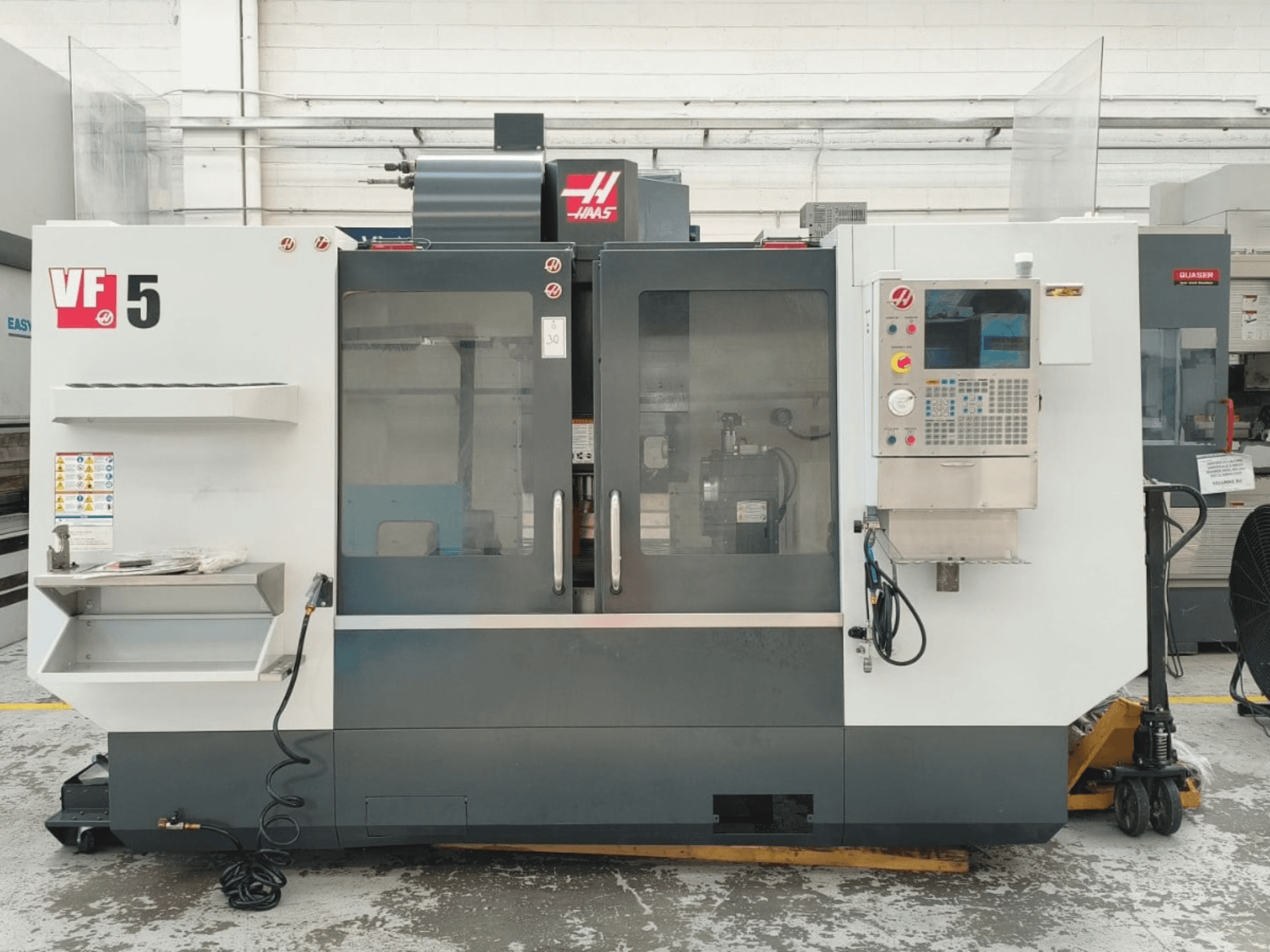 HAAS VF 5/40 dikey işleme merkezinin önden görünümü; kontrol paneli ve cam kapılar ile birlikte.